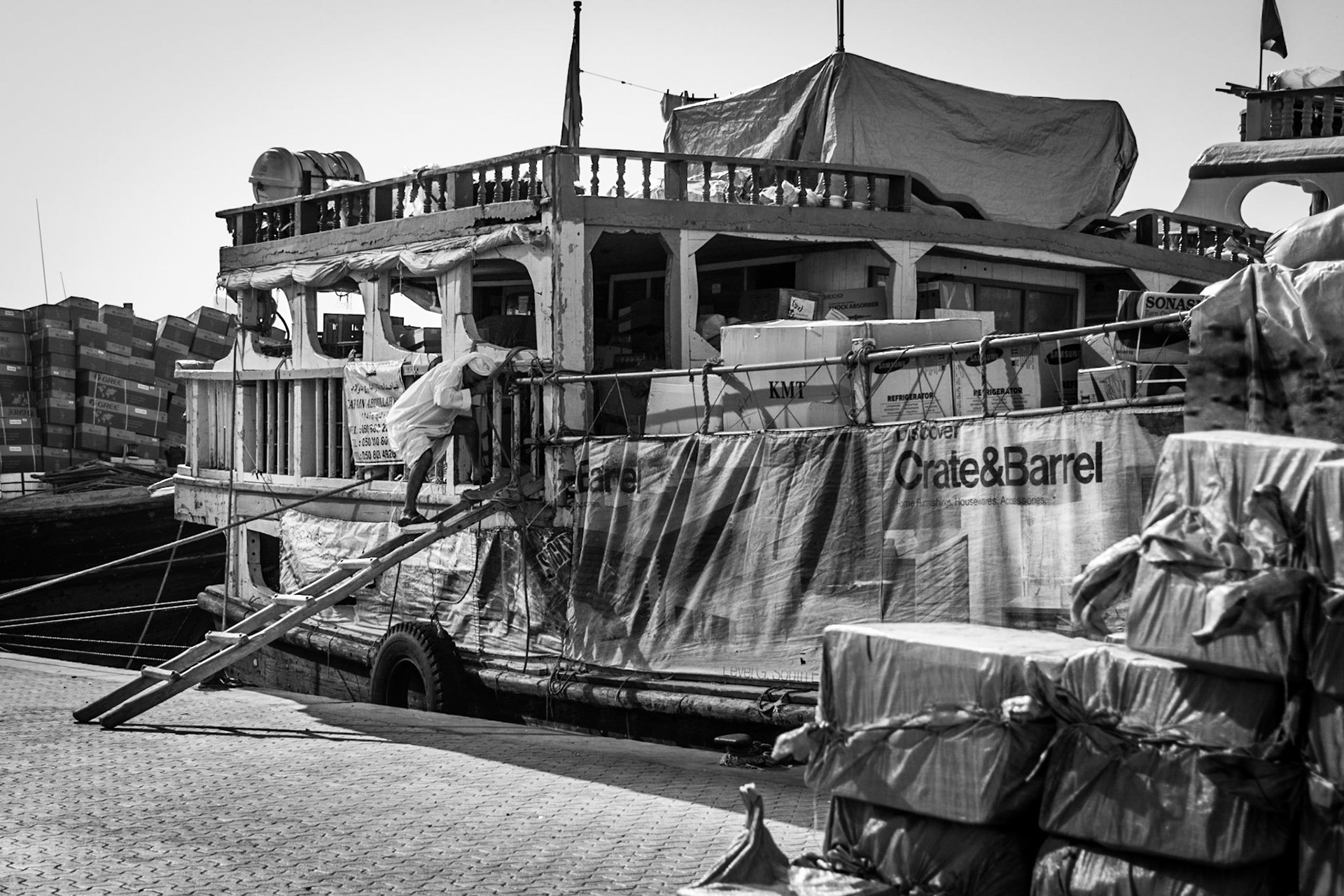 Old man climbing down a dhow in Dubai Creek, UAE