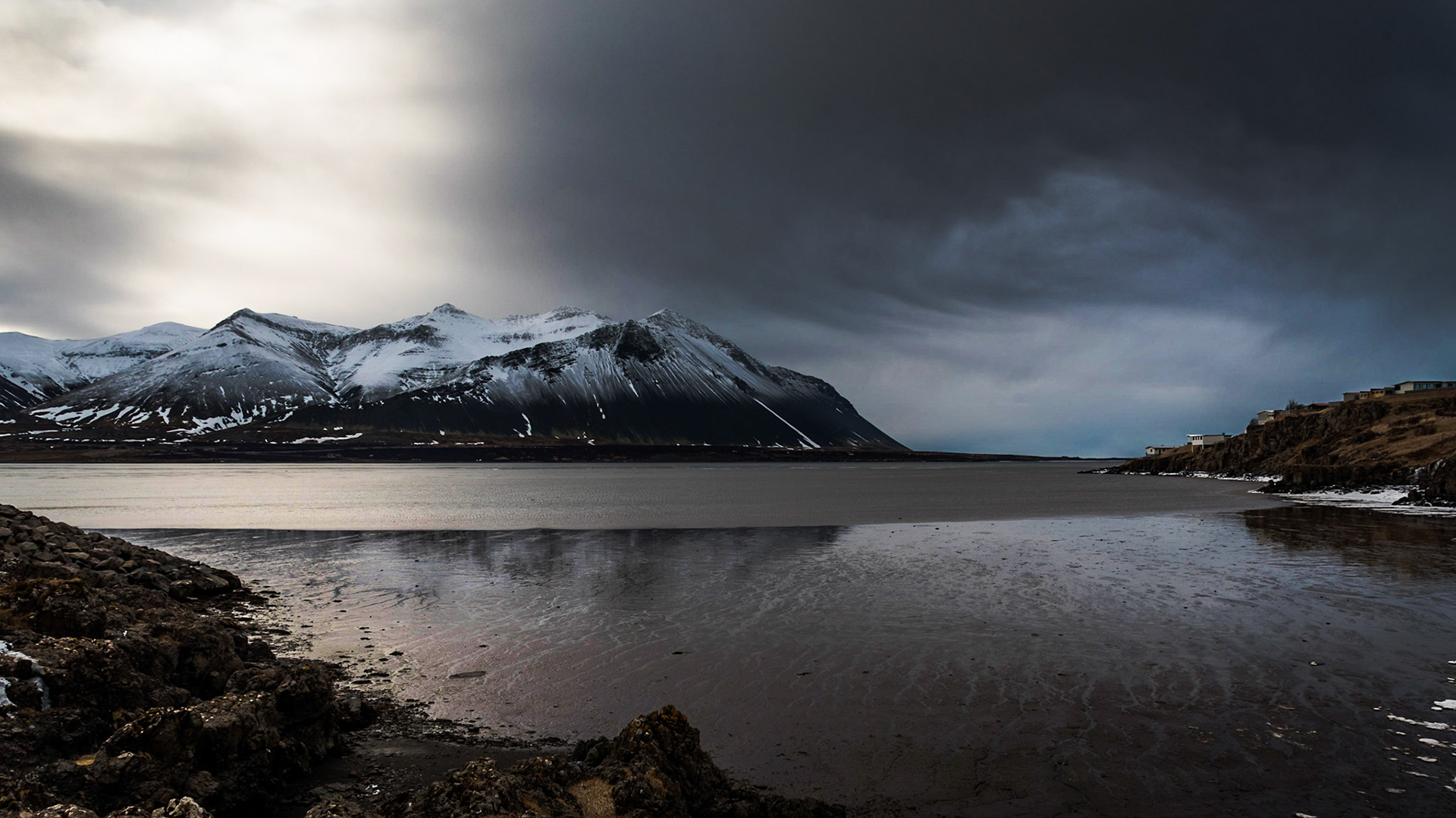 A storm is brewing next to Hafnarfjall mountain range as seen from the Borgarnes area in Iceland