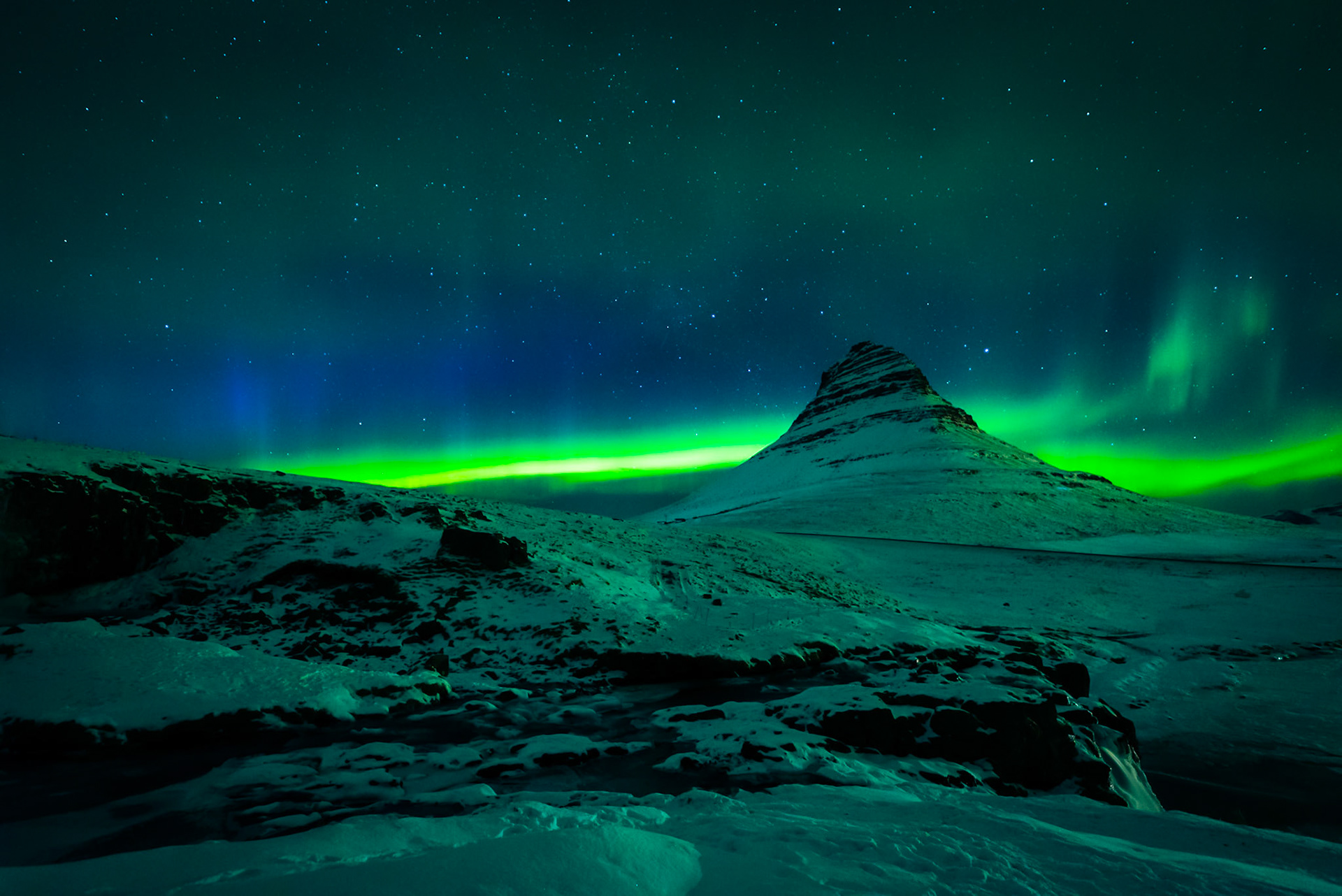 Northern lights over Kirkjufell and Kirkjufellsfoss waterfall in Iceland