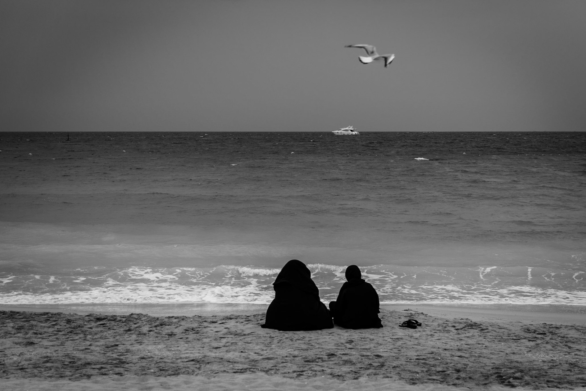 Young girls enjoying Jumeirah Beach while wearing abaya  in Dubai, UAE