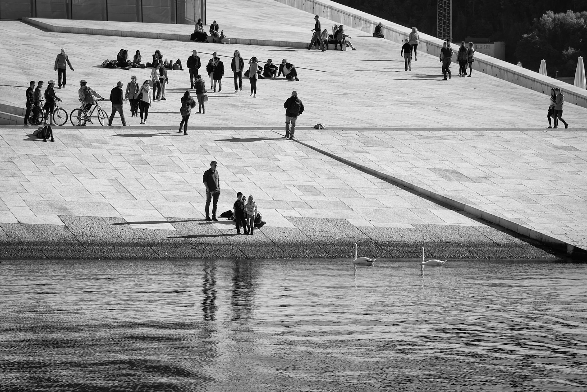 People enjoying the sun on the roof of the Oslo Opera House in Oslo, Norway