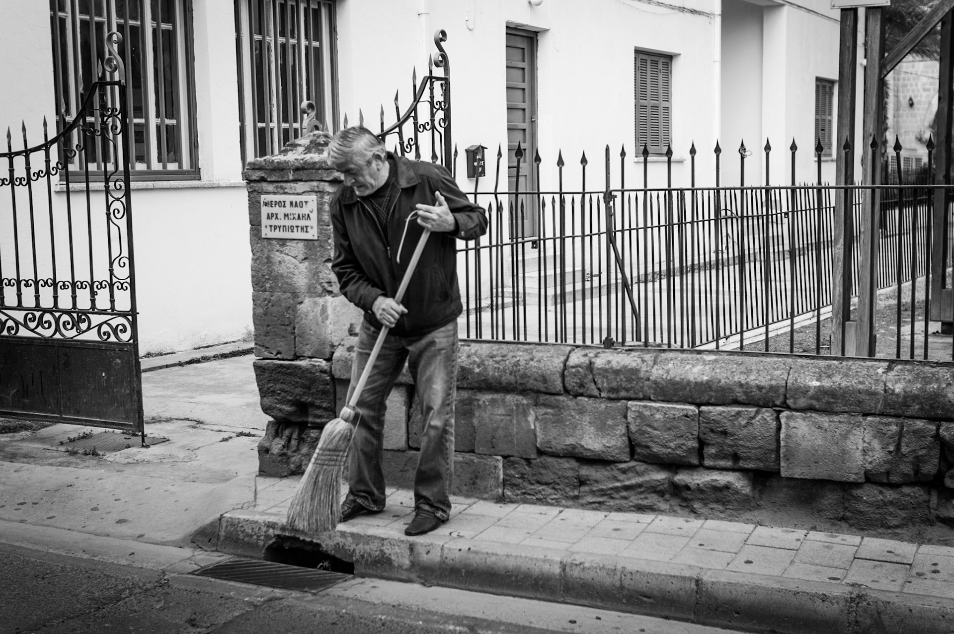 Man sweeping the street outside a church in Old Nicosia, Cyprus