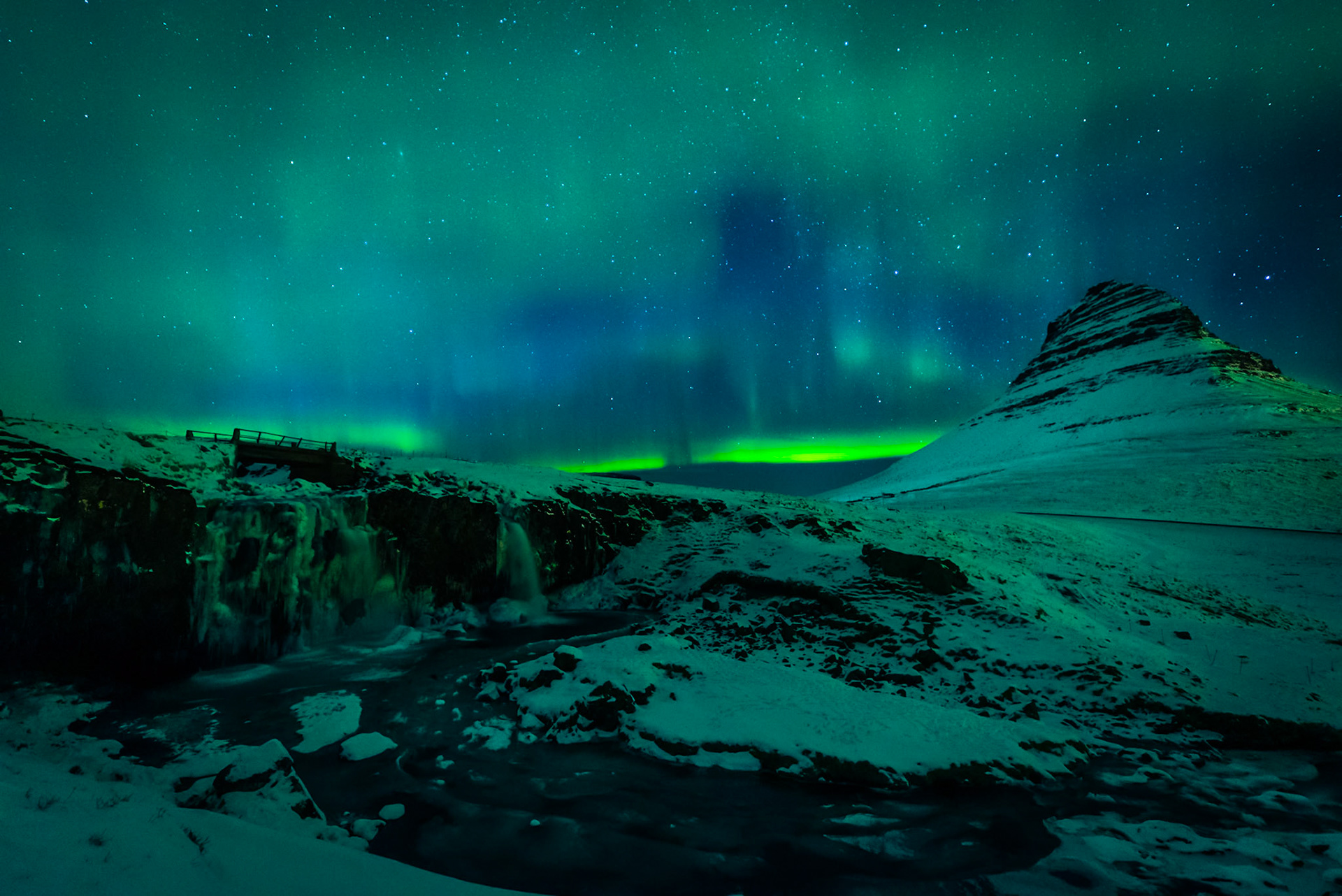 Northern lights over Kirkjufell and Kirkjufellsfoss waterfall in Iceland