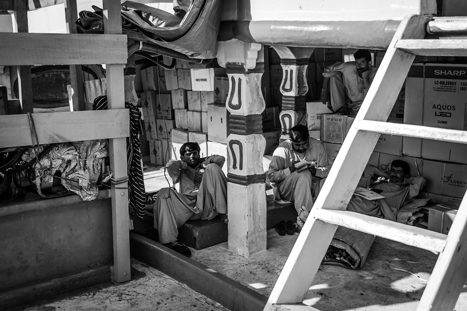 Crew members working on a dhow in Dubai Creek, UAE