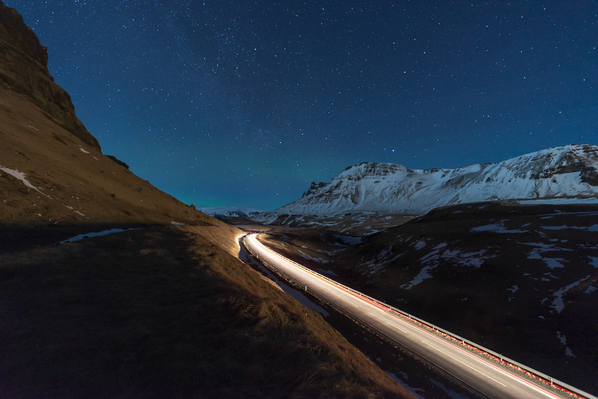 Northern Lights in the horizon over the hills around the village of Vik in Iceland