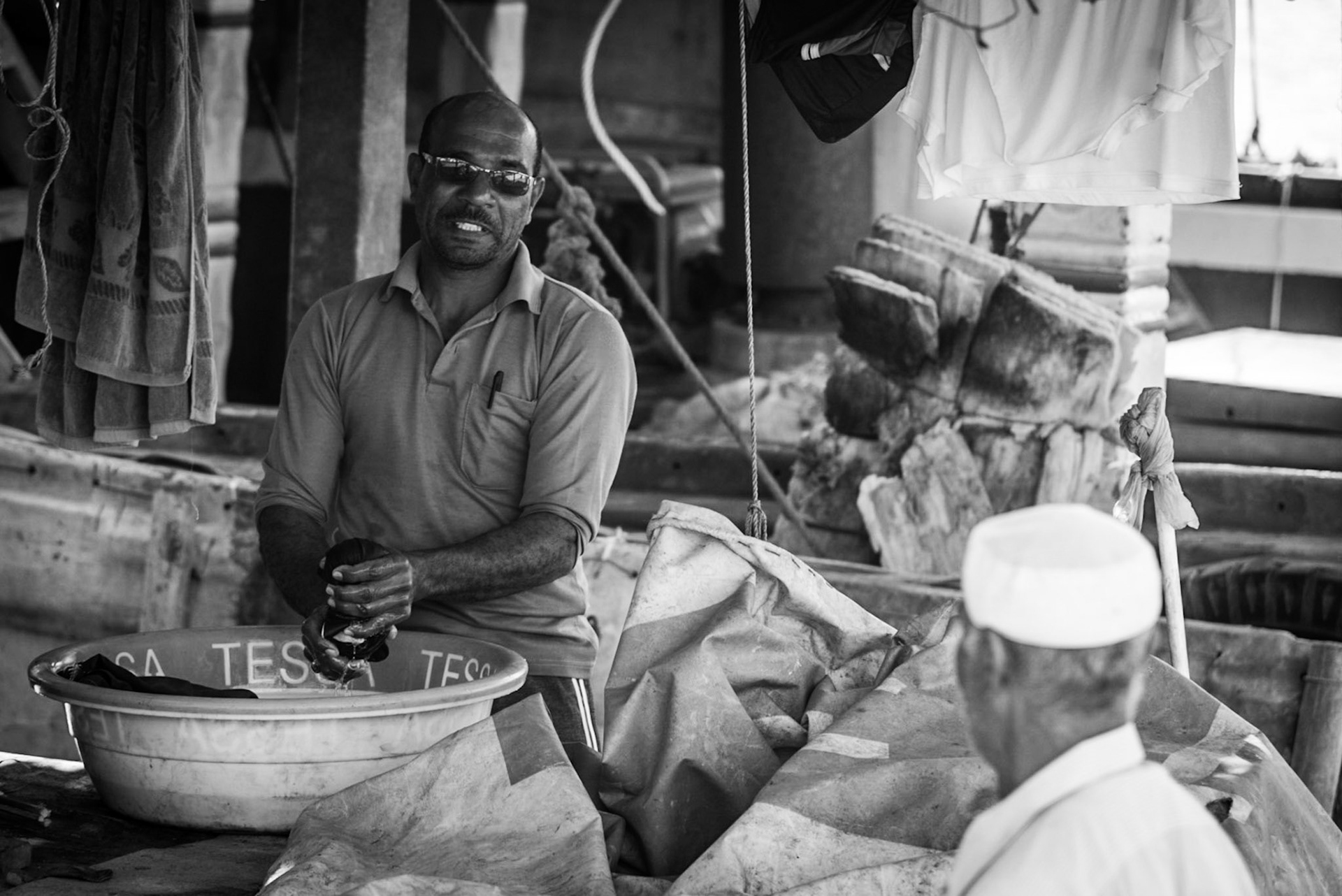 Crew member doing laundry on a dhow in Dubai Creek, UAE