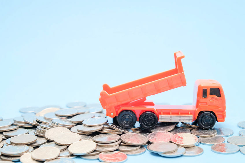 save money for investment concept truck toy and Coins on blue background