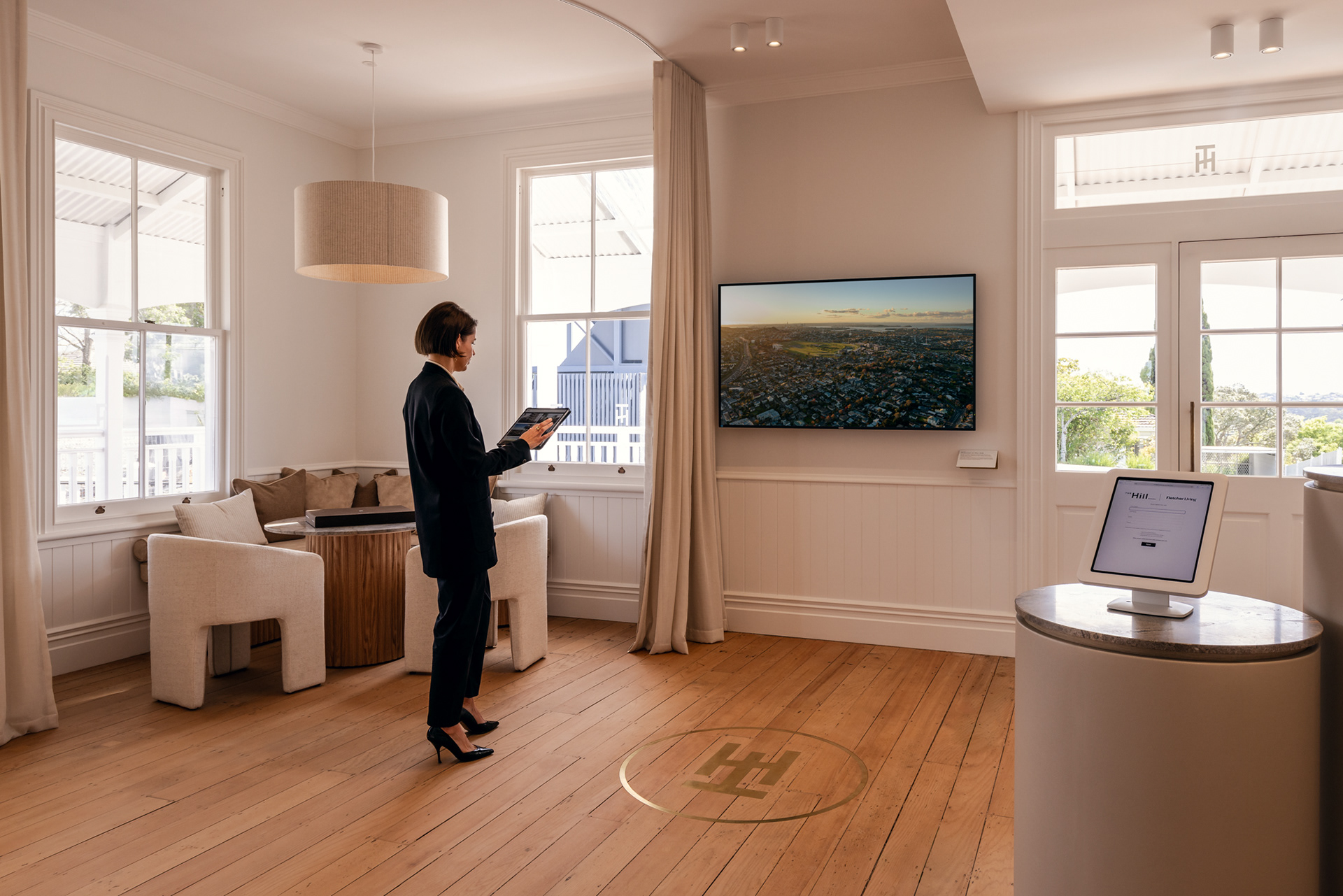 Interior of Fletcher Building’s The Hills display suite with an iPad controlling the wall-mounted digital display