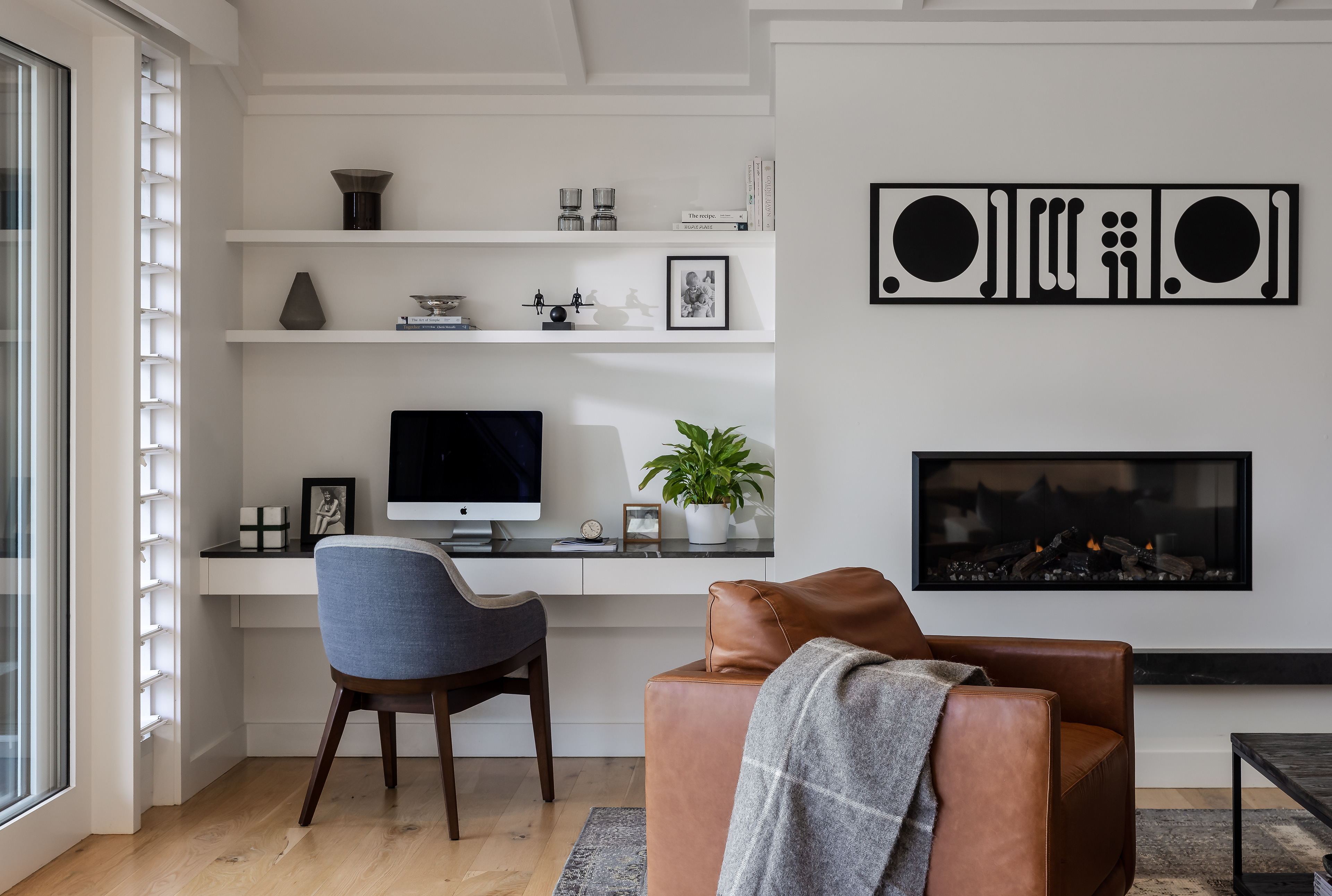 Detail of the Remuera bungalow living area with leather seating, timber cabinetry and curated interior styling