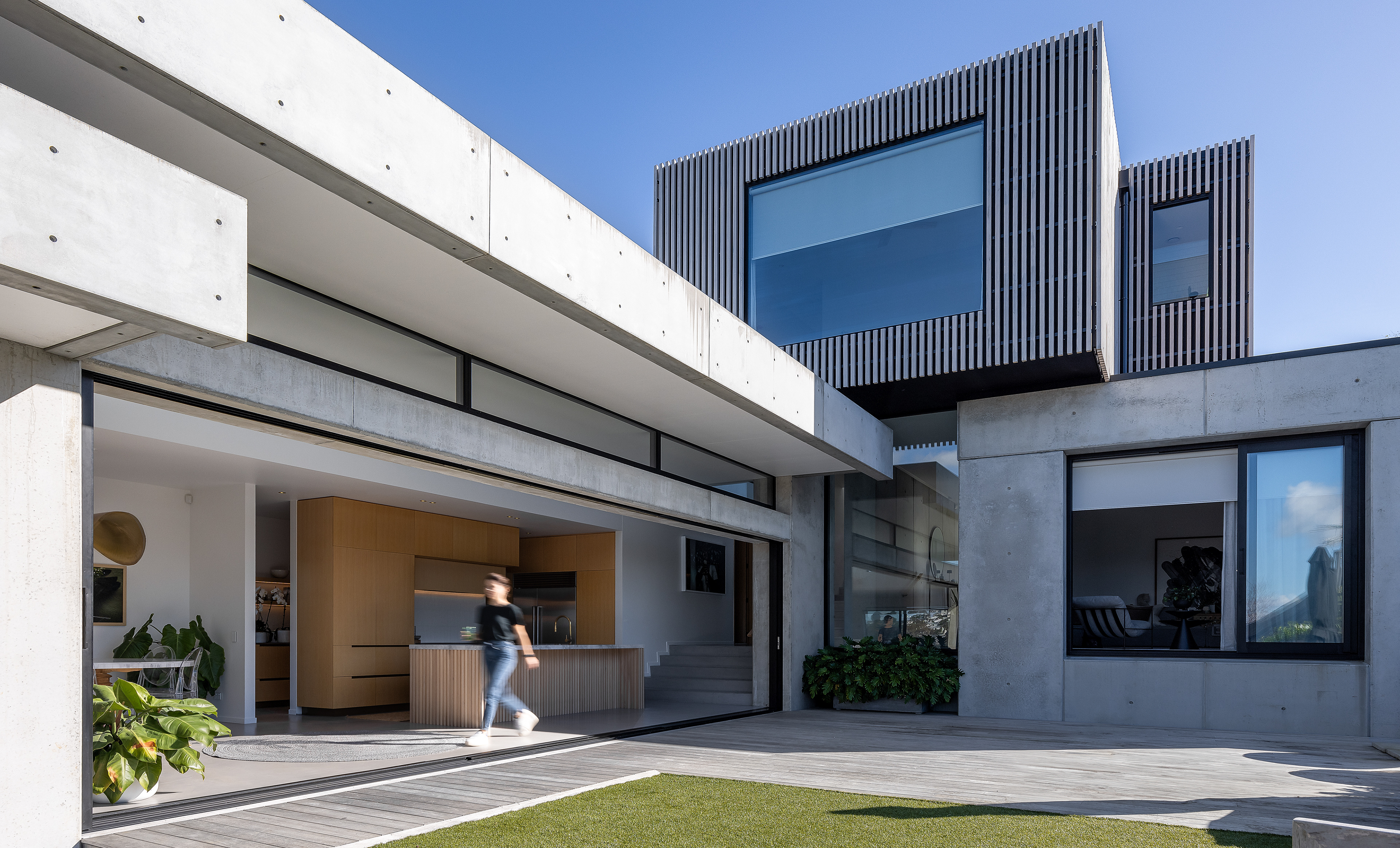 Contemporary concrete Auckland home with open-plan kitchen connecting to outdoor living