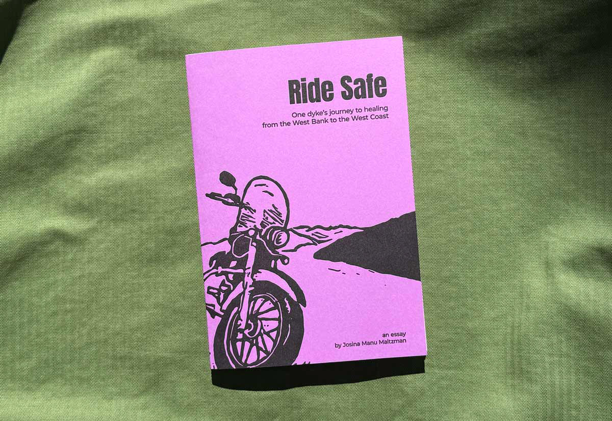 A bright purple book cover with a black drawing of a motorcycle in the foreground parked on the side of a long winding road with mountains in the background