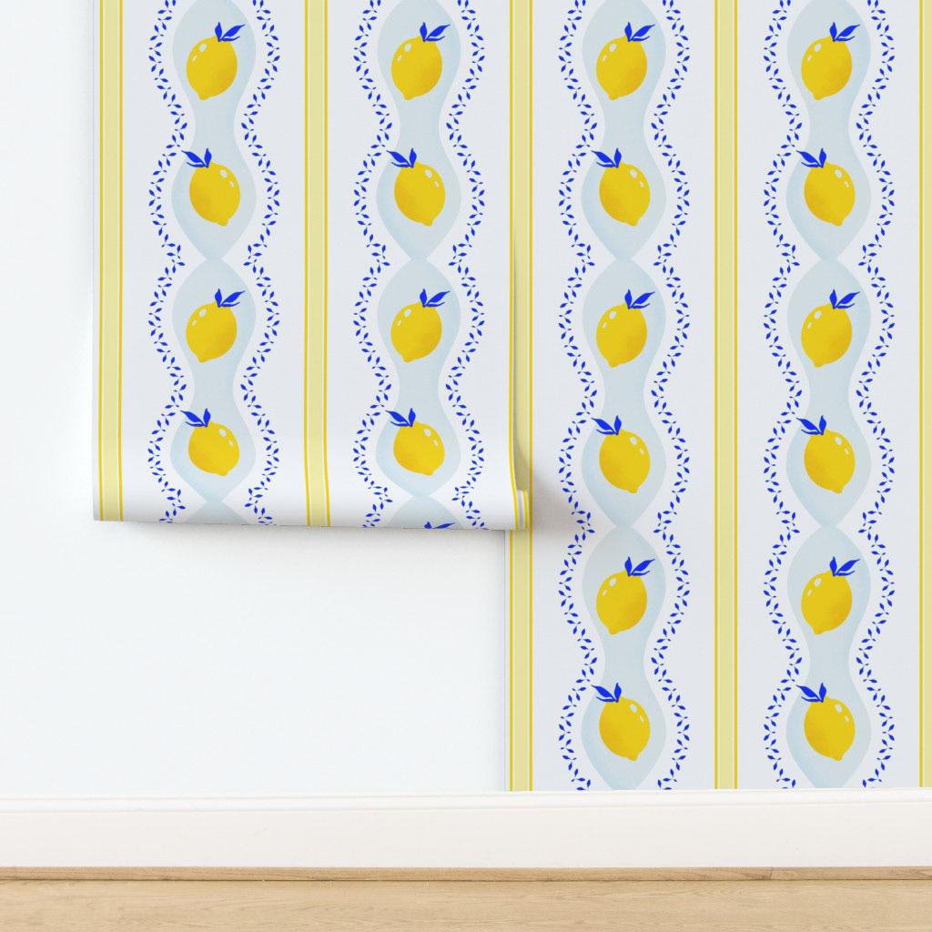 Wallpaper featuring a repeating pattern of bright yellow lemons with blue leaf accents arranged in vertical stripes on a white background, suitable for kitchen or dining room walls.