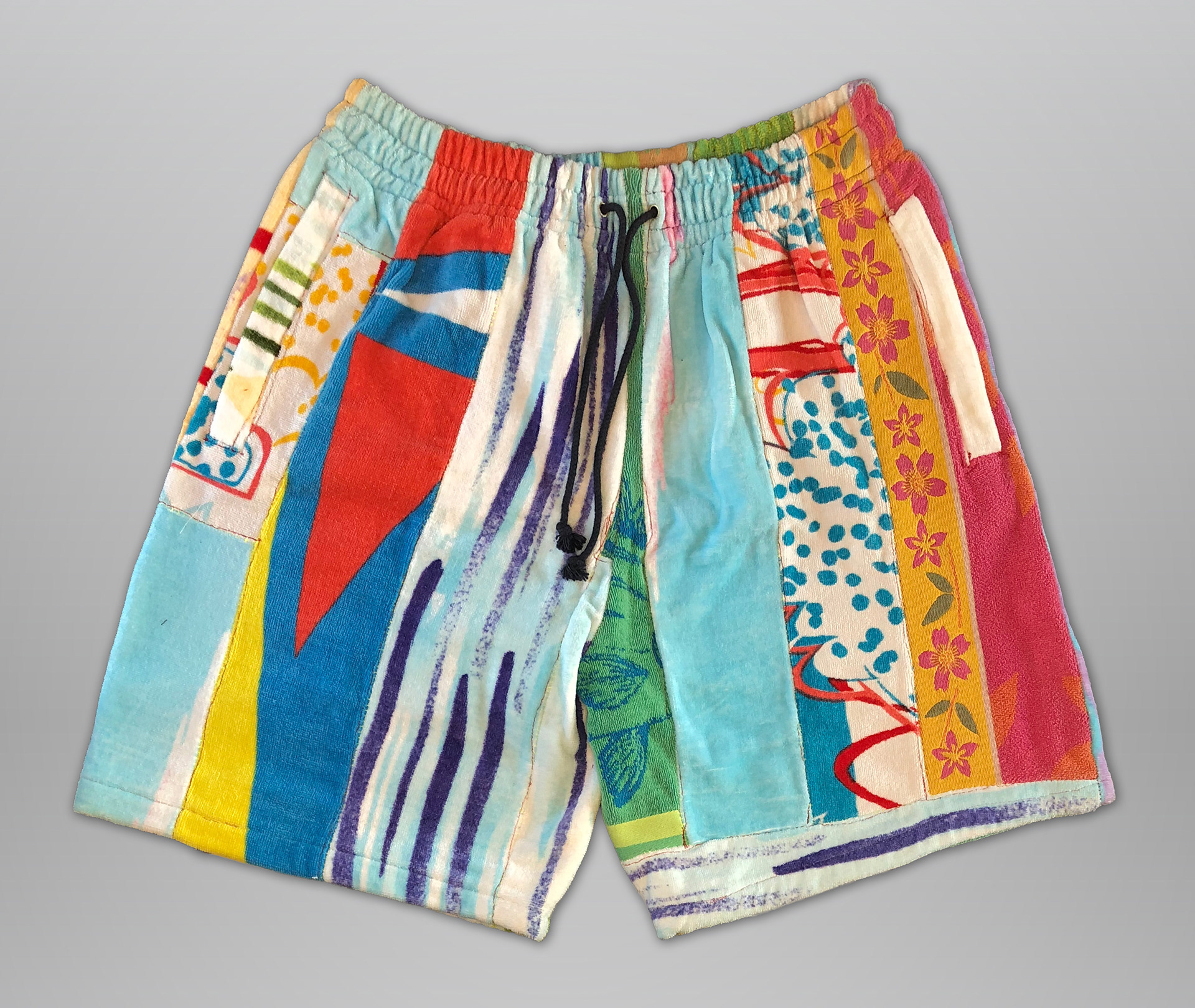 Sewn from beach towel scraps. Features elastic waistband, drawstring, and 2 deep side hem zippered pockets. 