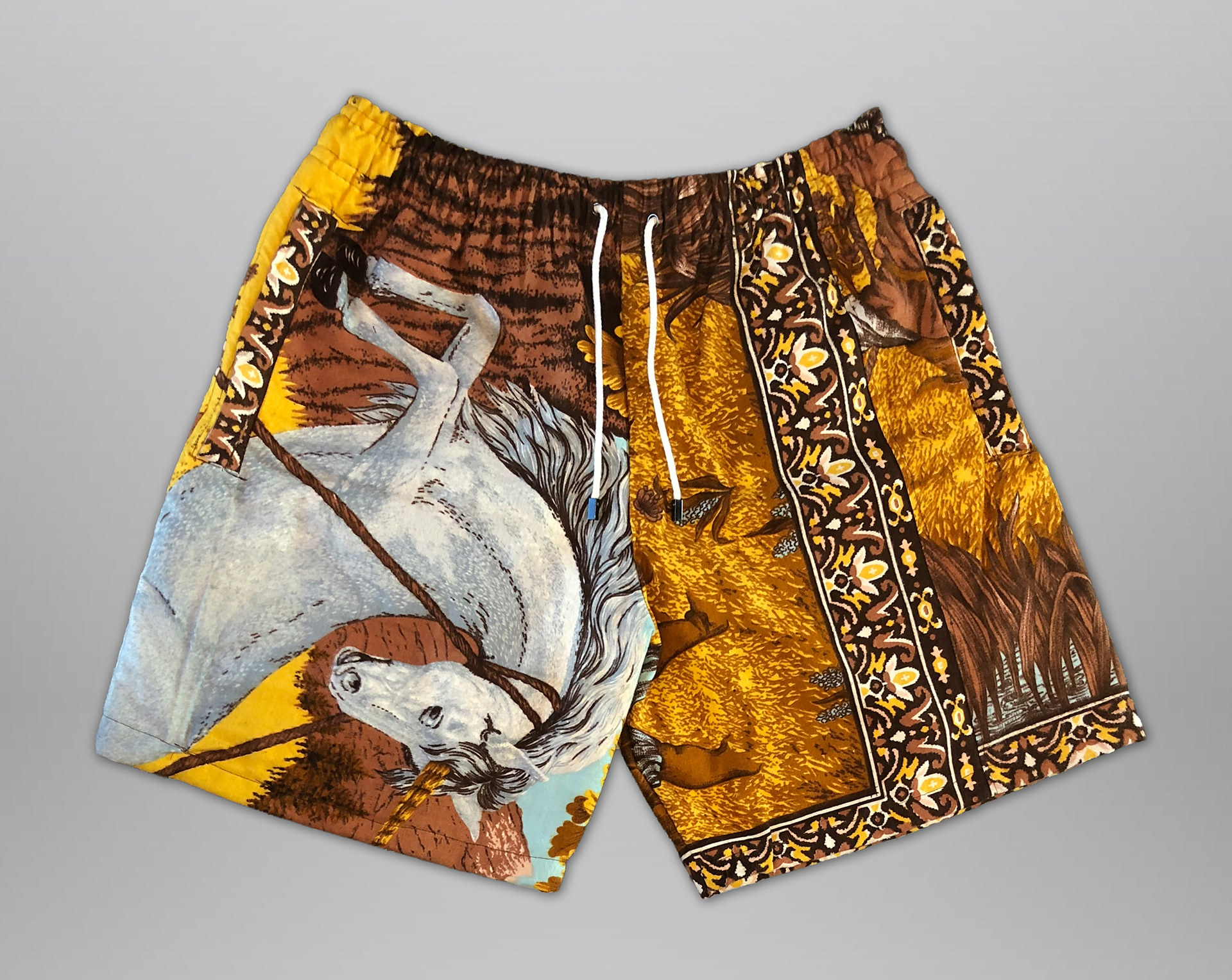 Sewn from unicorn tapestry. Features elastic waistband, drawstring, and 2 deep side hem zippered pockets. Slightly cropped fit (above the knee).