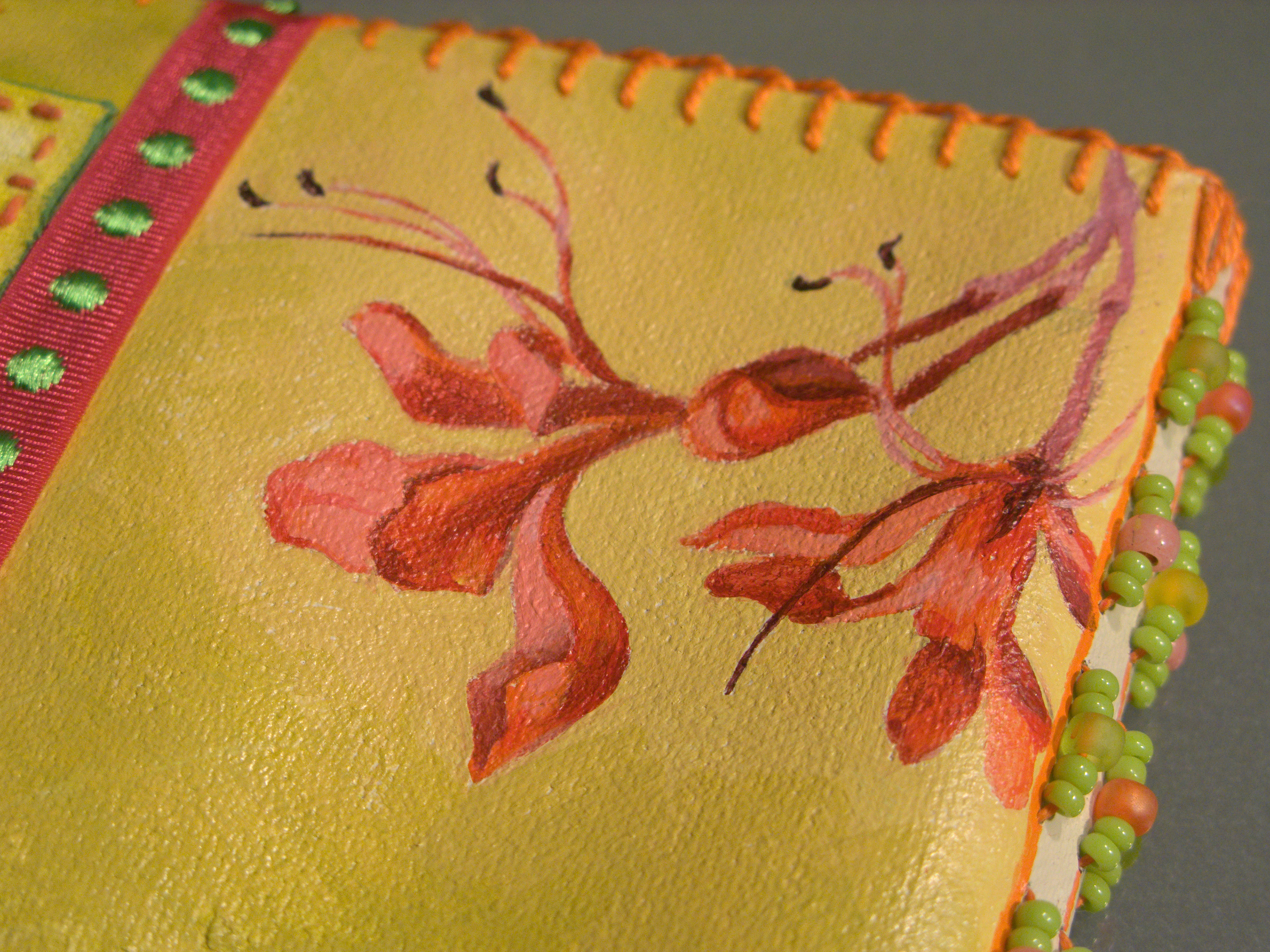 A tiny square quick book with scrap canvas cover and pages. Added beads on the spine sewing and a ribbon closure. I think I painted the flowers from life - I liked to sneak flowers from the neighbors yards occasionally to brighten my desk.