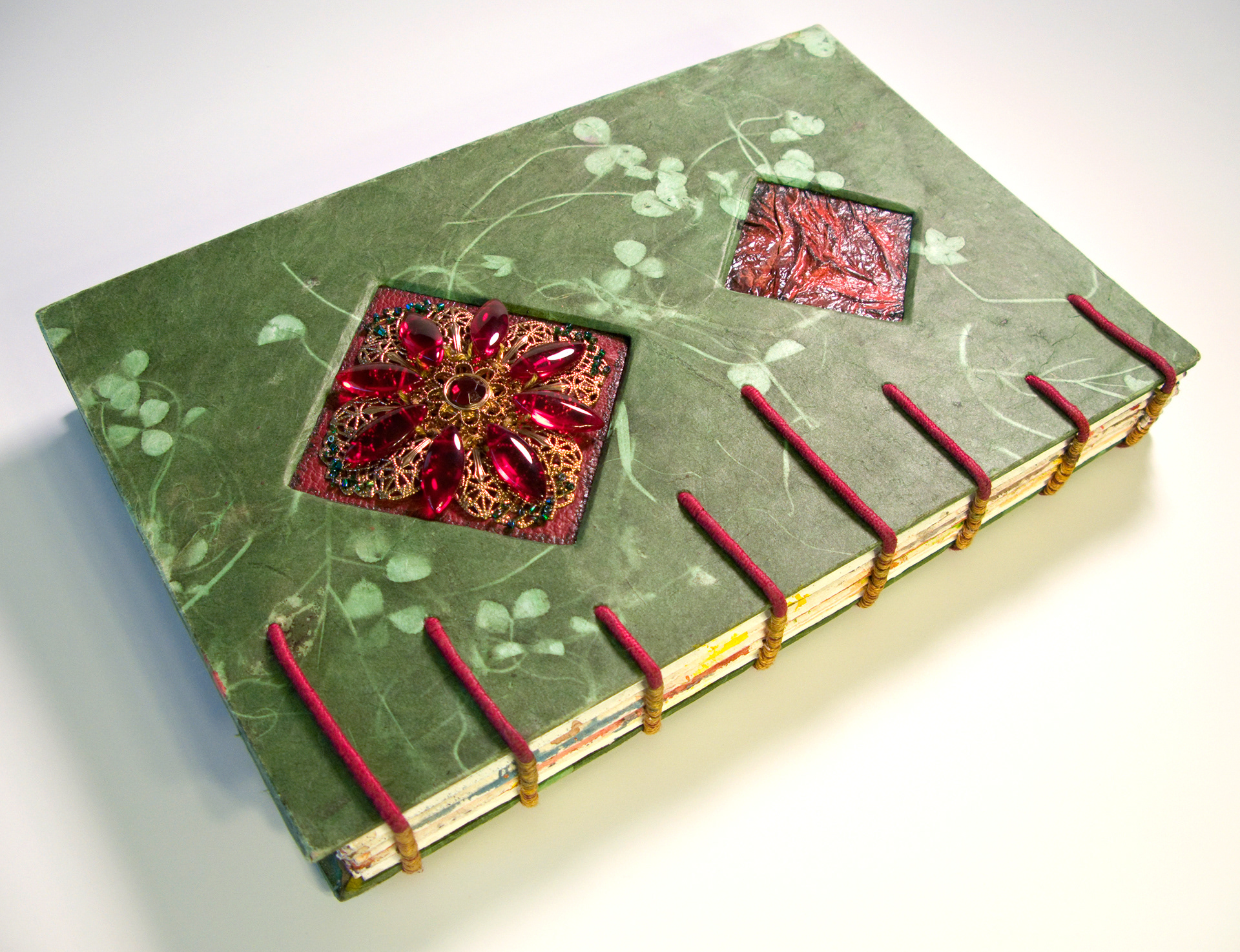 The smaller bottom cutout is a handmade red paper with a thick laquer finish that highlights the deep ripples and the color. The clover paper is one of my favorites, especially with the red accents I added!