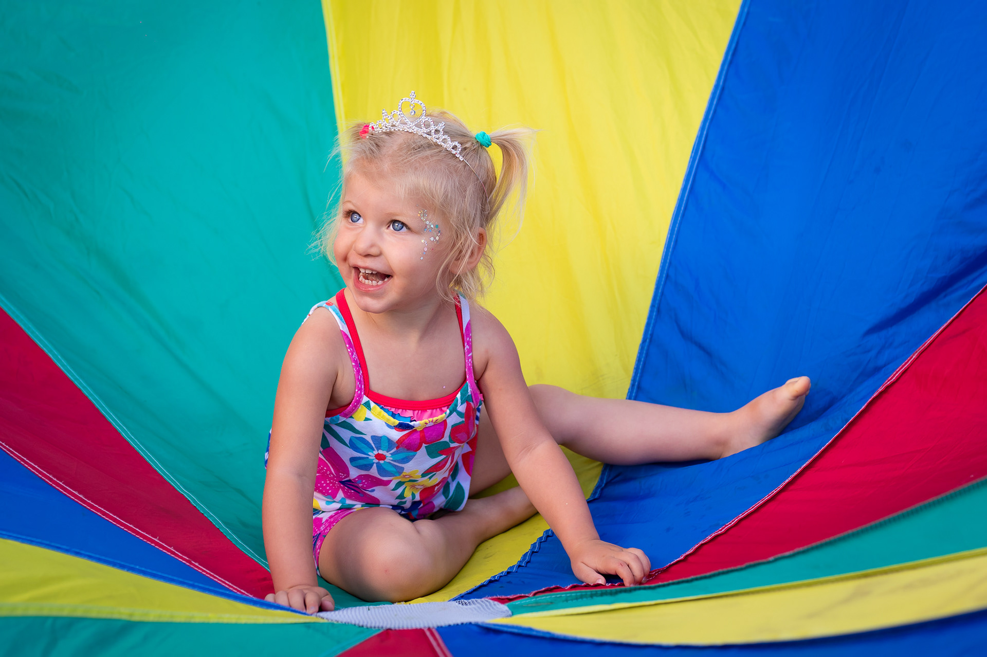 Birthday girl in the parachute game at her party.
