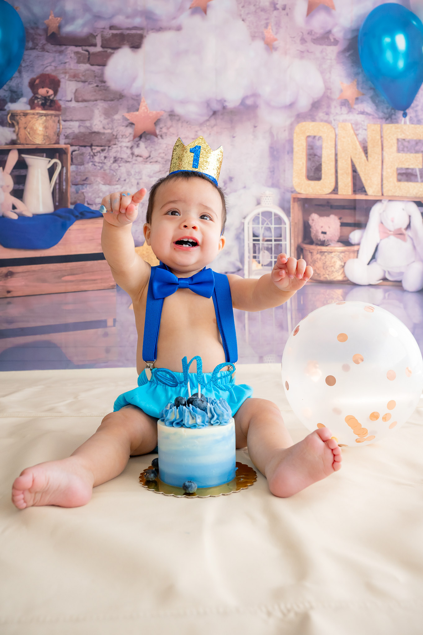 Newly minted 1 year old celebrating with a blueberry cake.