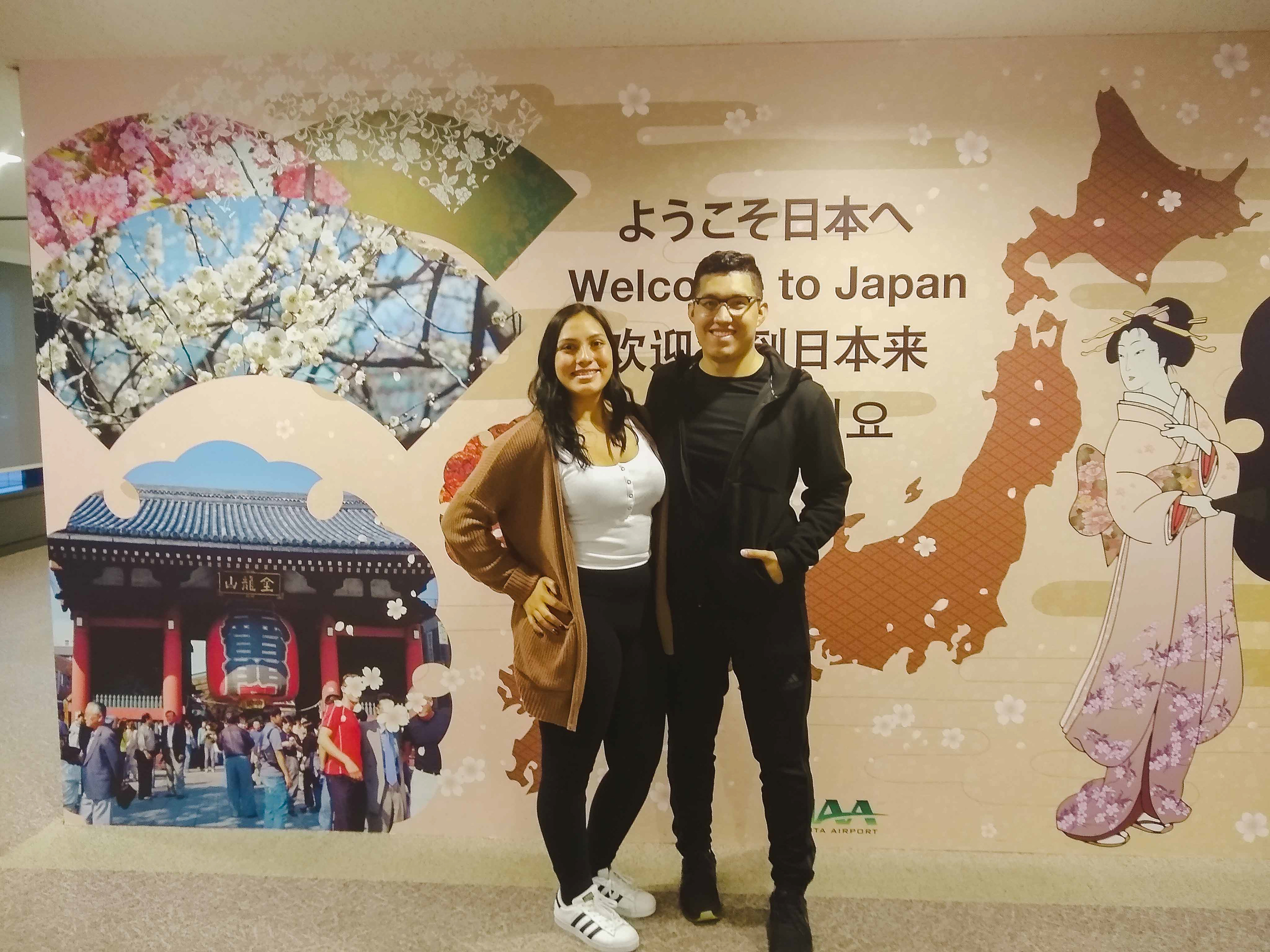 Oscar and Vanessa taking a photo in front of the welcome to japan sign at Tokyo, Japan.