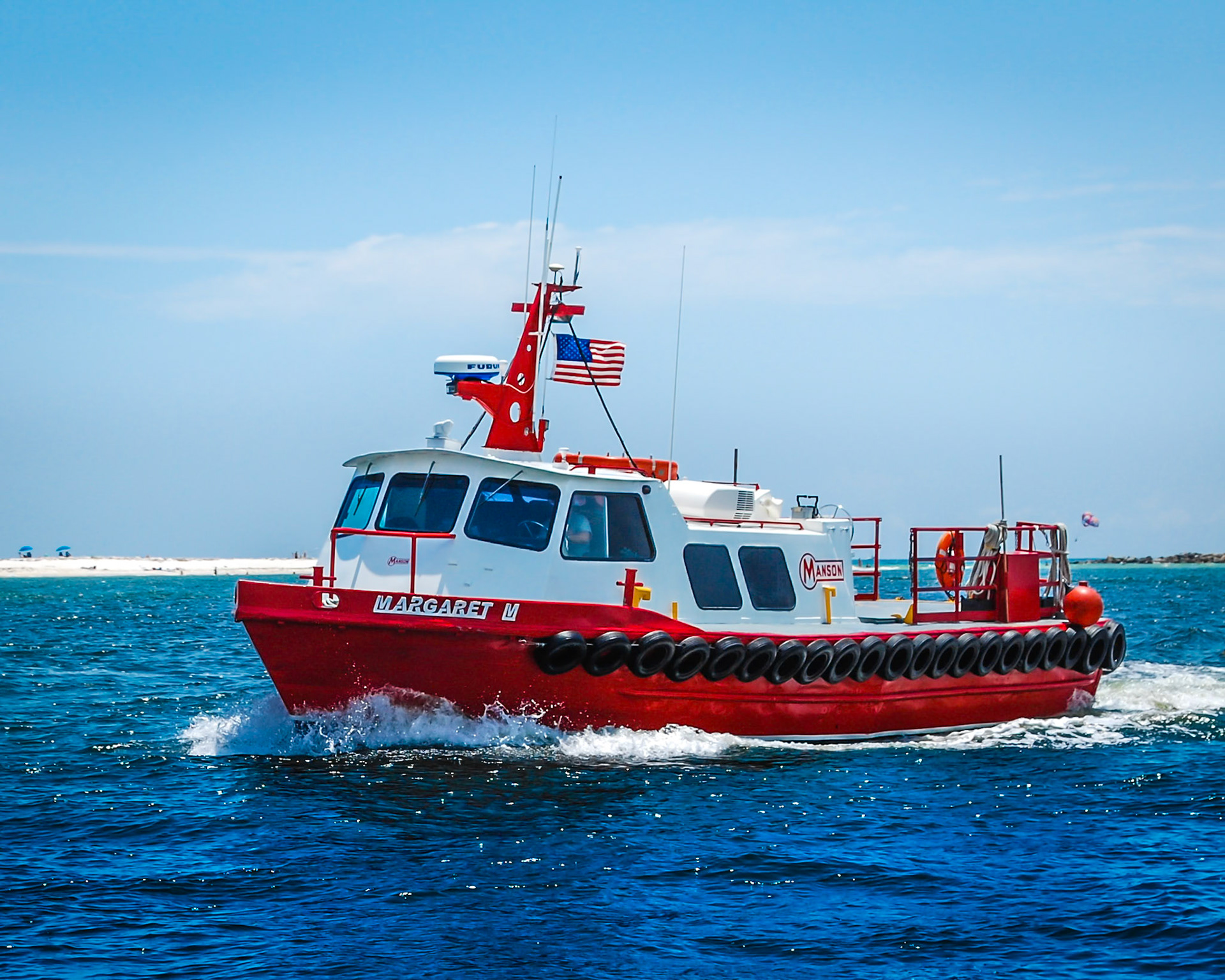 Red and white Margaret M boat from Manson Construction going through Perdidio pass in Orange Beach, Alabama.
