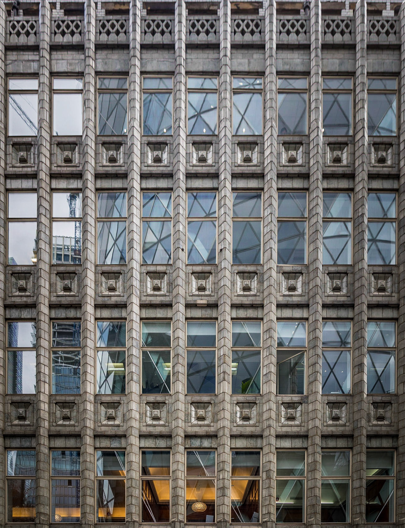 There is no doubt that the Gherkin (30 St Marys Axe) is an interesting piece of architecture, indeed I have many images of it these past 35 weeks already but none that I felt were good enough.

I was actually walking back from elsewhere in the city when I noticed this art deco style building called Holland House, and then the reflection of the Gherkin in its Windows, the single orange lamp towards the bottom also caught my eye and I knew exactly the image I wanted to create.