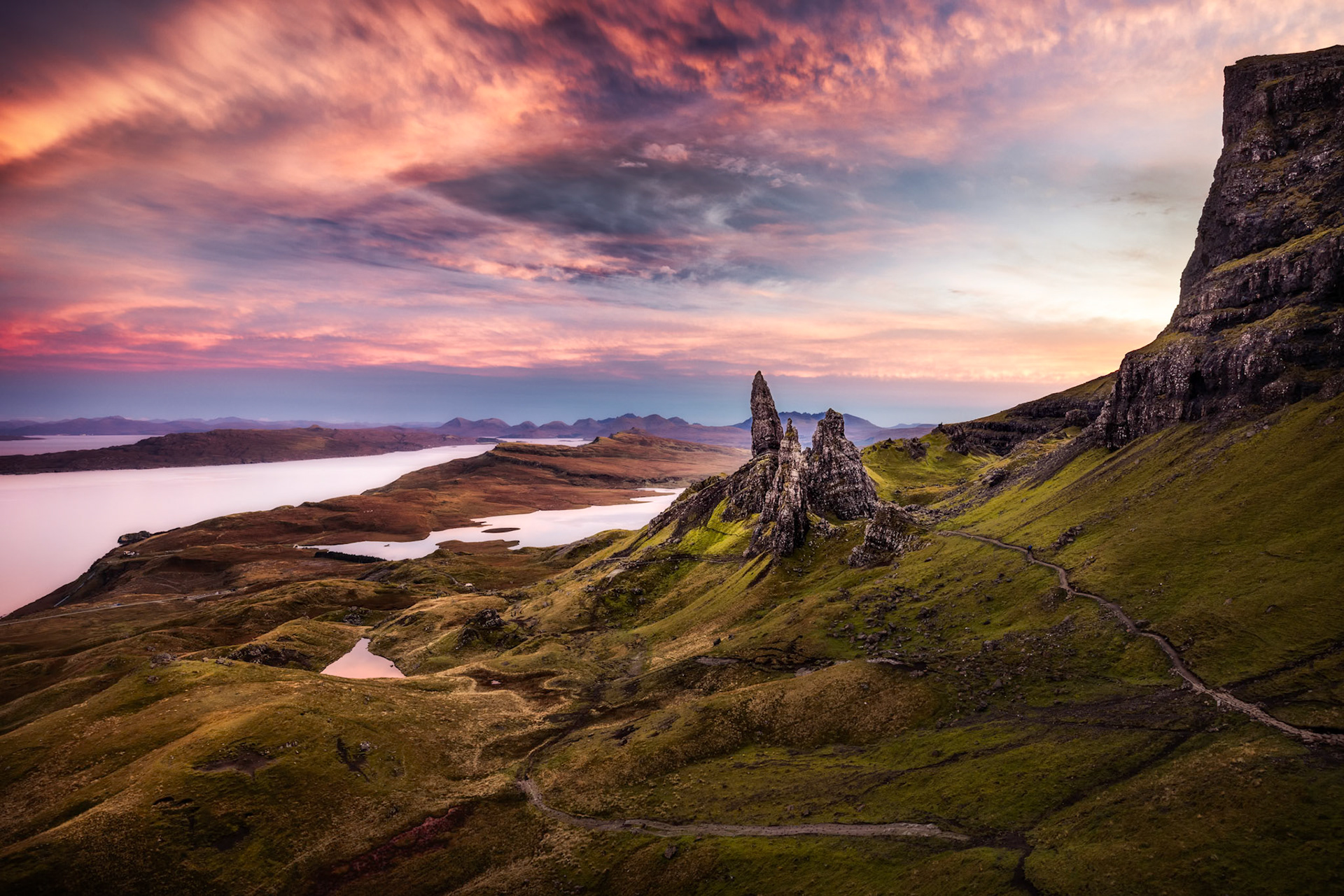 The old man of Storr is an iconic landscape on the Isle of Skye in Scotland and one which I've always wanted to photograph.  So I took a 350 mile road trip and wild camped with my brother through Scotland to see it.  The weather in Scotland is often changeable so we hiked up early on what was a pleasant sunny day at the bottom but when reaching the summit the weather was significantly colder. For four hours I paced in circles and jogged on the spot to try and warm up whilst waiting for the sun to set. One by one, all of the other photographers left, discouraged by the overcast sky.  Finally alone with my brother, the sun dipped below the horizon and a kaleidoscope of colour appeared in the sky.  If you look closely halfway down the path on the right hand side you can see the last group of photographers to leave which I left in to remind me to always arrive early and leave late and to give a sense of scale of this incredible landscape.