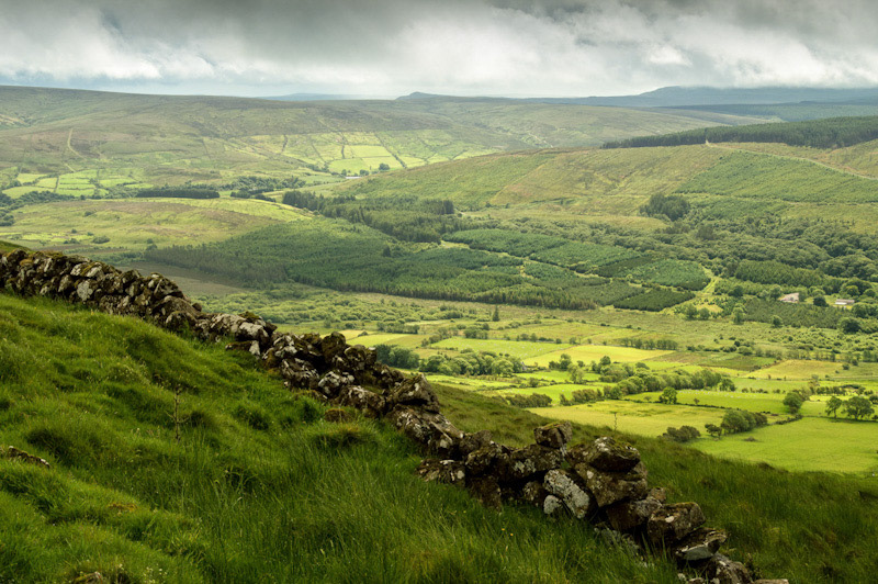 View from the slopes of Knocklayd. Rolling green hills and patterned fields stretching toward the horizon.