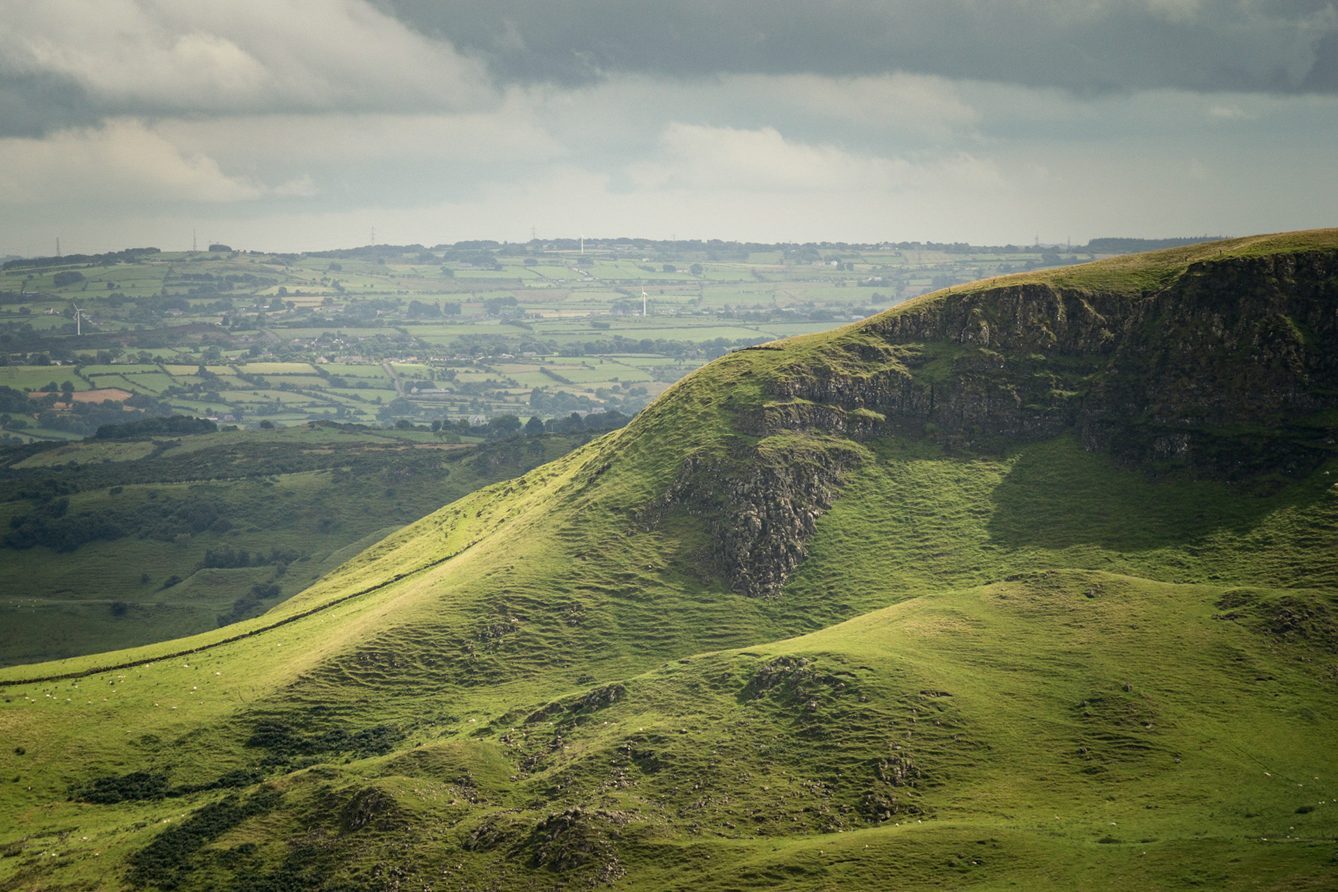Low directional sunlight highlighting the green terraced fields on the slopes of Knock Dhu.