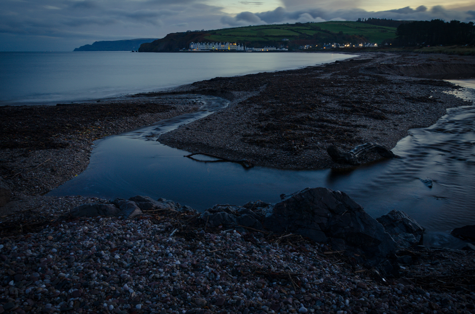 Cushendun coast at night under a subtle moonlit sky.