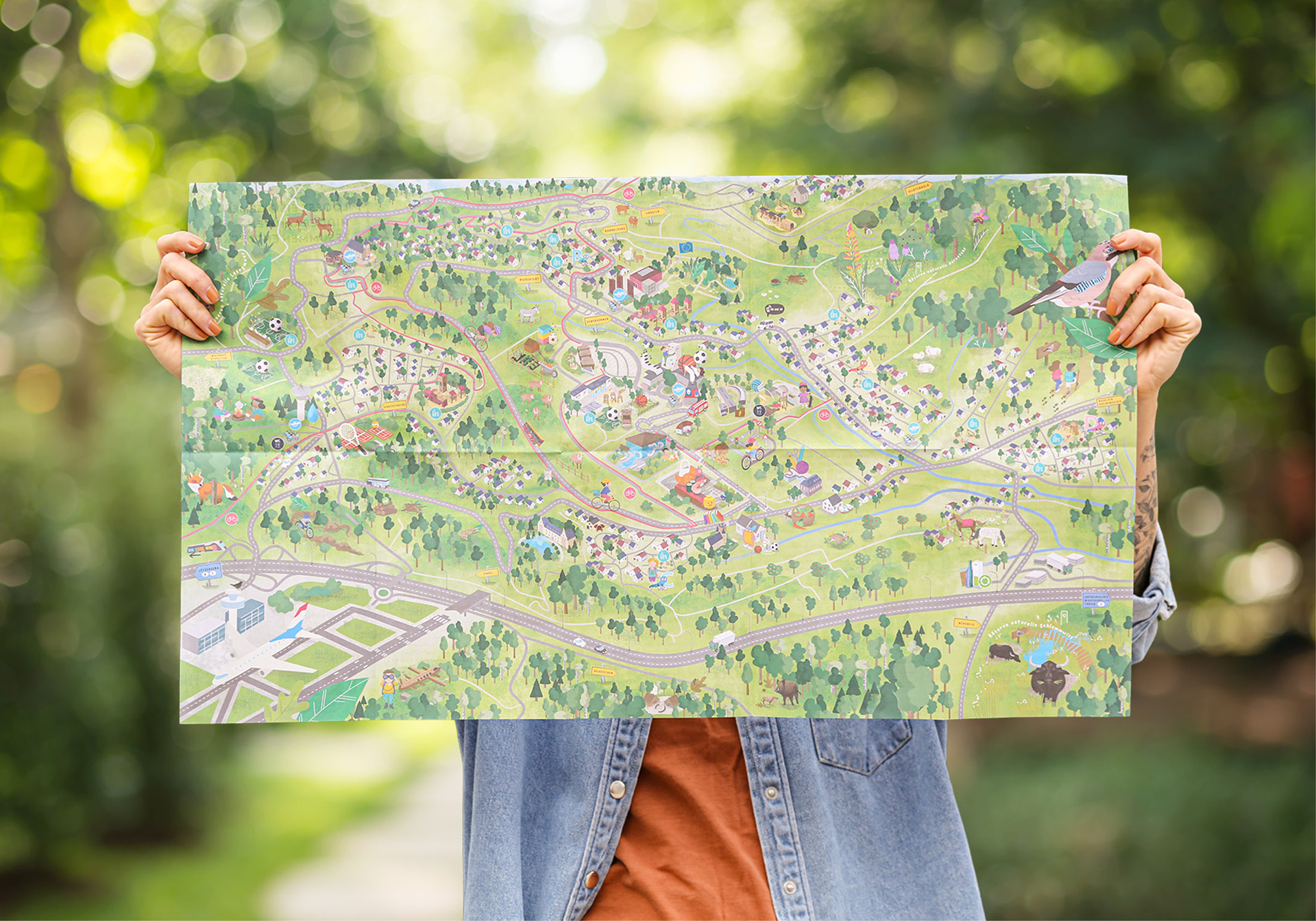 Photo of a woman holding up and presenting the community's children's map.
