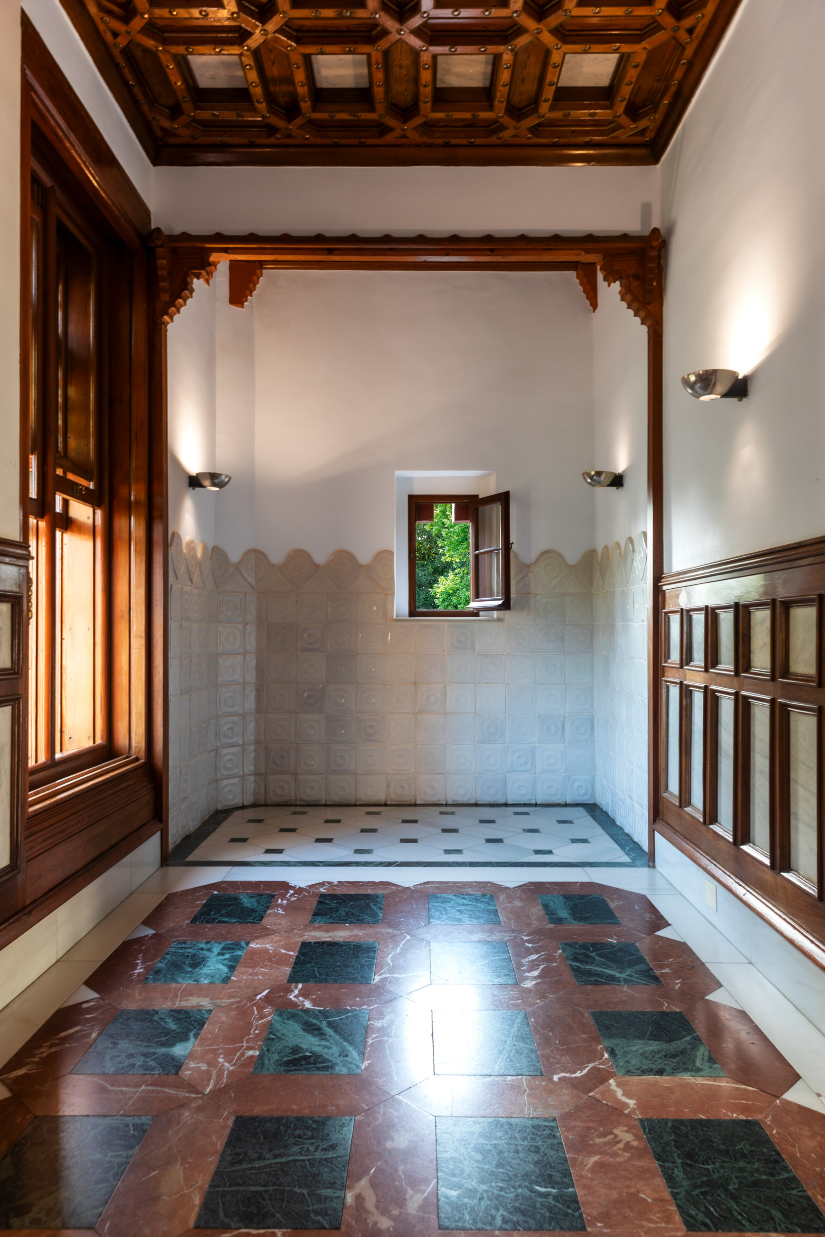 Red and black marble in the bathroom, below a coffered timber ceiling of the kind used throughout the house.