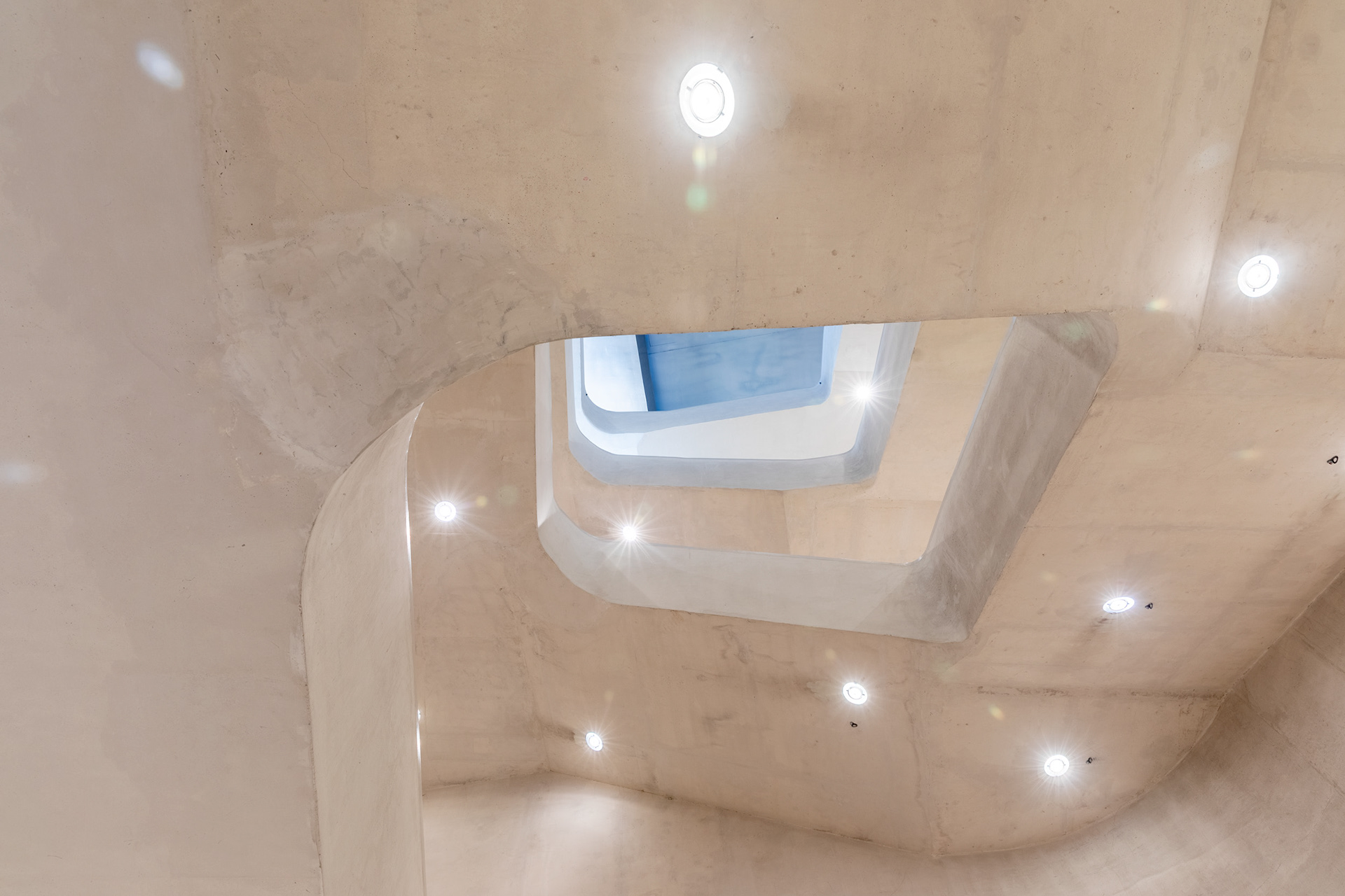 The same stairwell from the bottom, looking up. The conversion excavated two new levels beneath the original building.