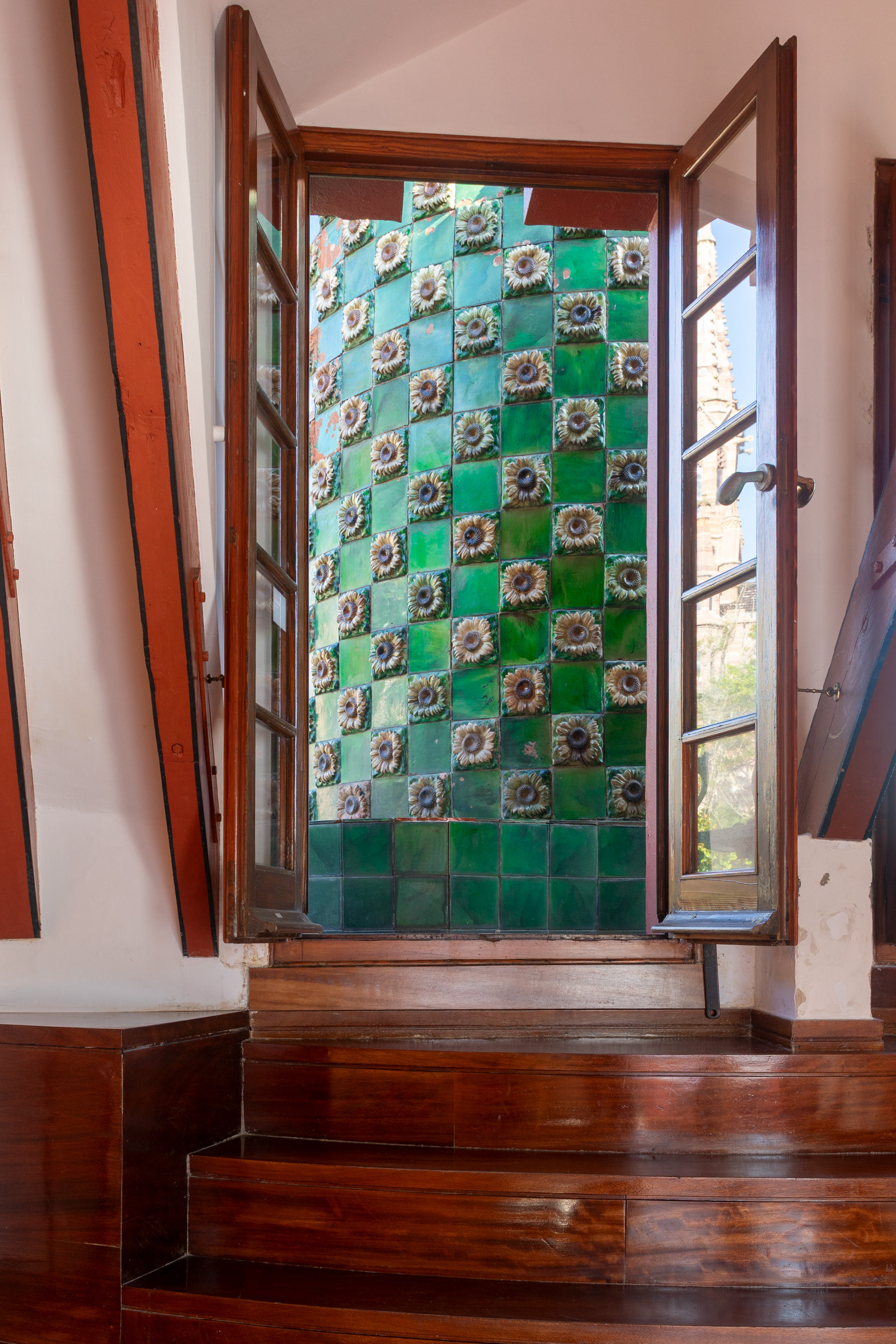 On the tower the tiles are set in a checkerboard, plain green alternating with the sunflower relief.