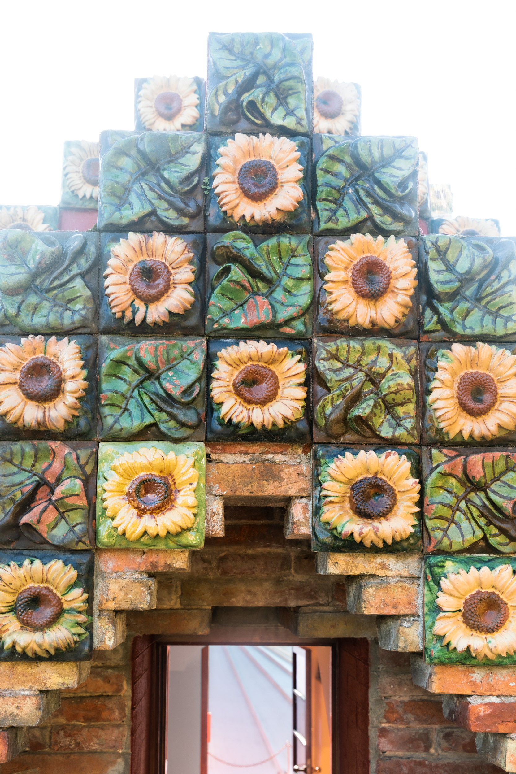 Moulded in relief, the tile alternates with leaf panels. The same sunflower appears at Casa Vicens in Barcelona, begun in the same years.
