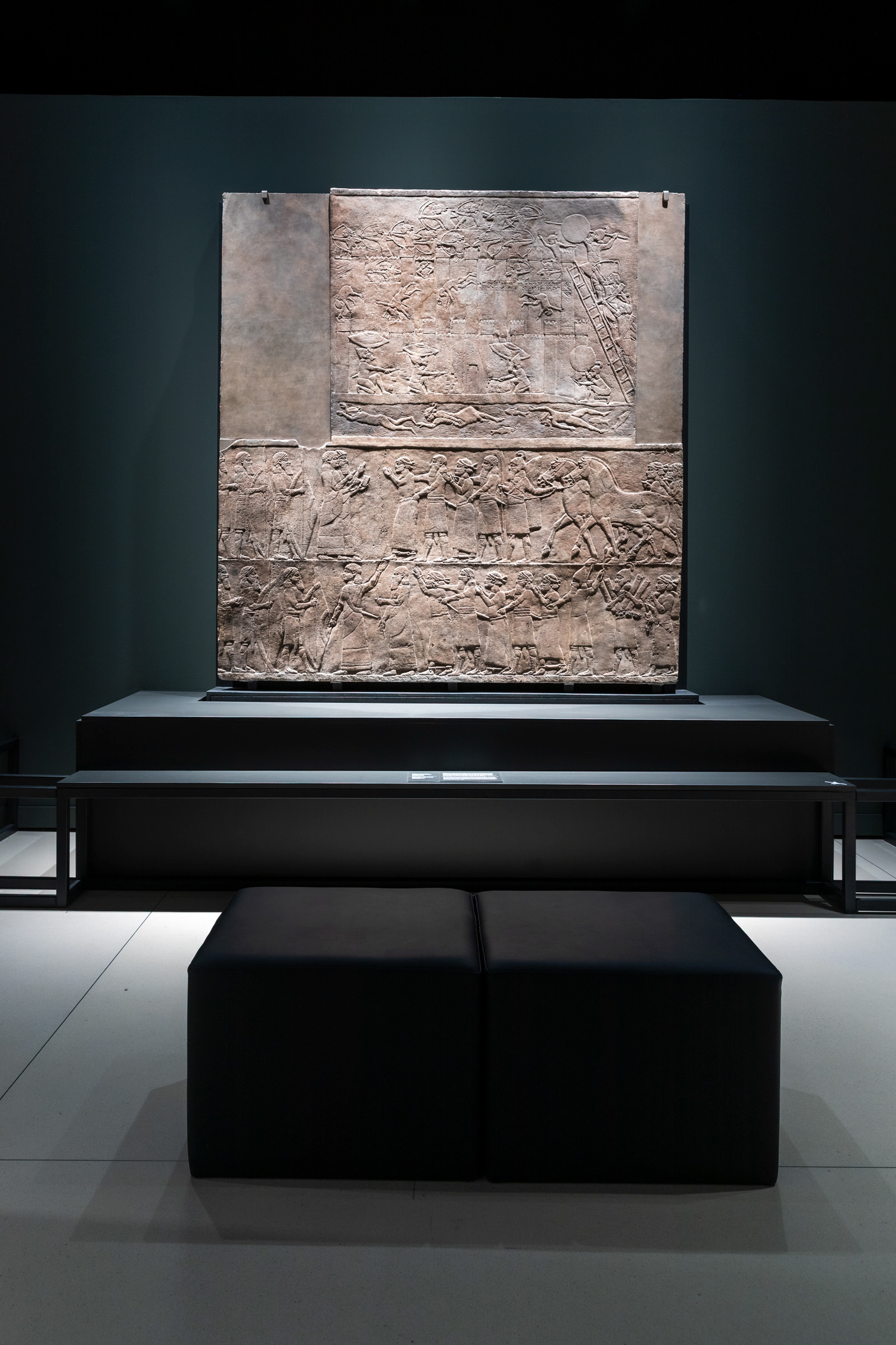 The Hamanu Relief (c. 645–640 BC) on display at CaixaForum Madrid. This striking Neo-Assyrian palace panel captures the brutal siege of an Elamite fortress and the subsequent deportation of its citizens. [1] (https://www.britishmuseum.org/collection/object/W_1856-0909-17-18_2), [2] (https://en.wikipedia.org/wiki/Ashurbanipal)