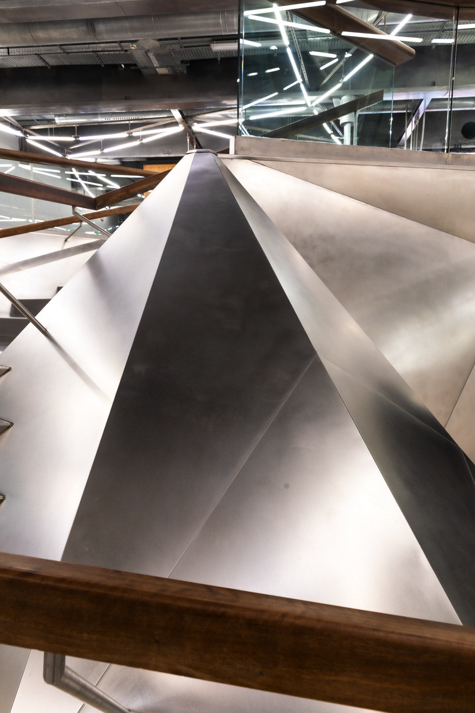 The underside of the folded stainless-steel staircase, seen from the lobby.