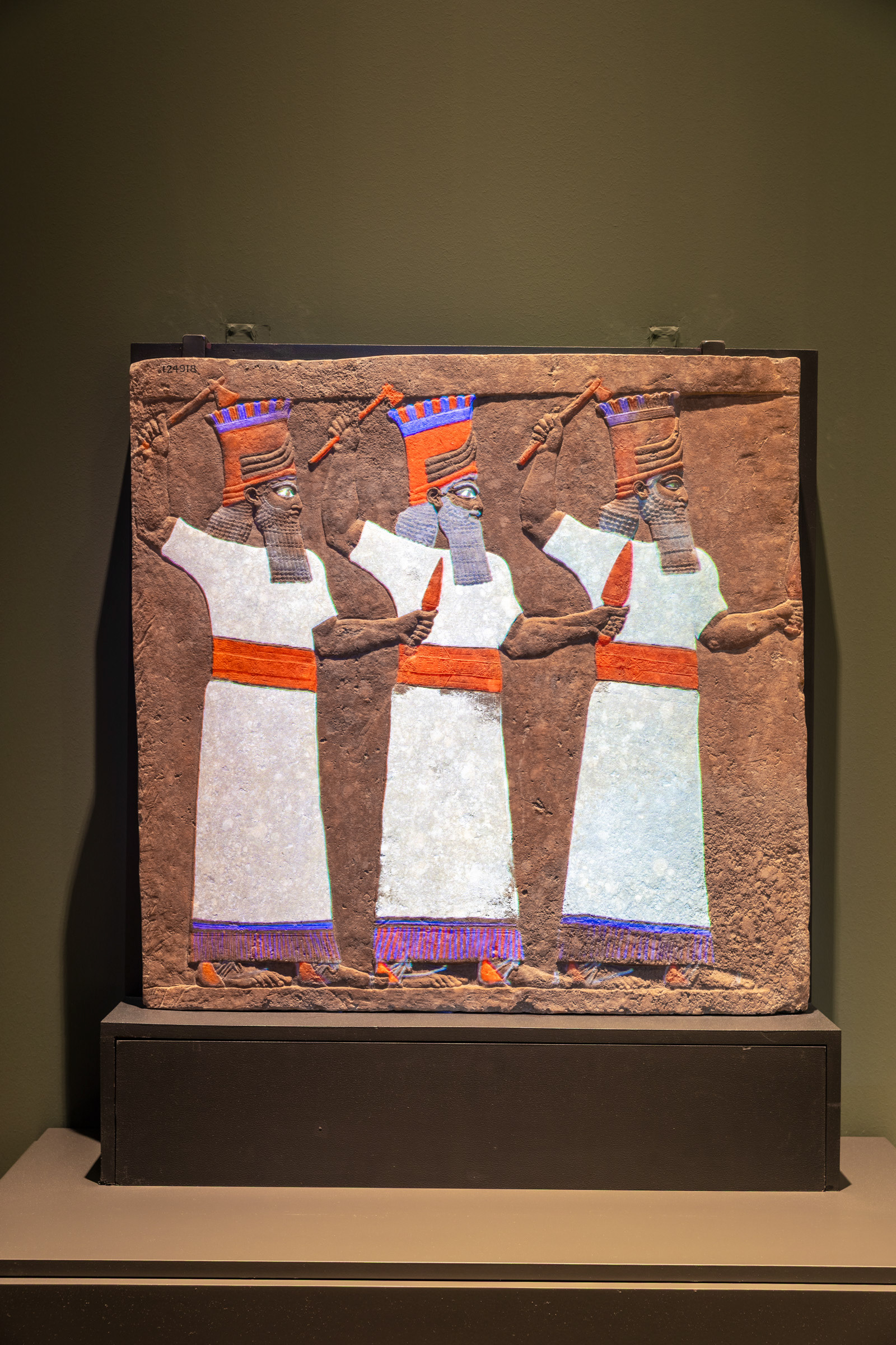 The Sebitti Panel (c. 645–640 BC) on display at CaixaForum Madrid. The vibrant colors are created using projection mapping based on original paint particles found on the ancient Assyrian relief.