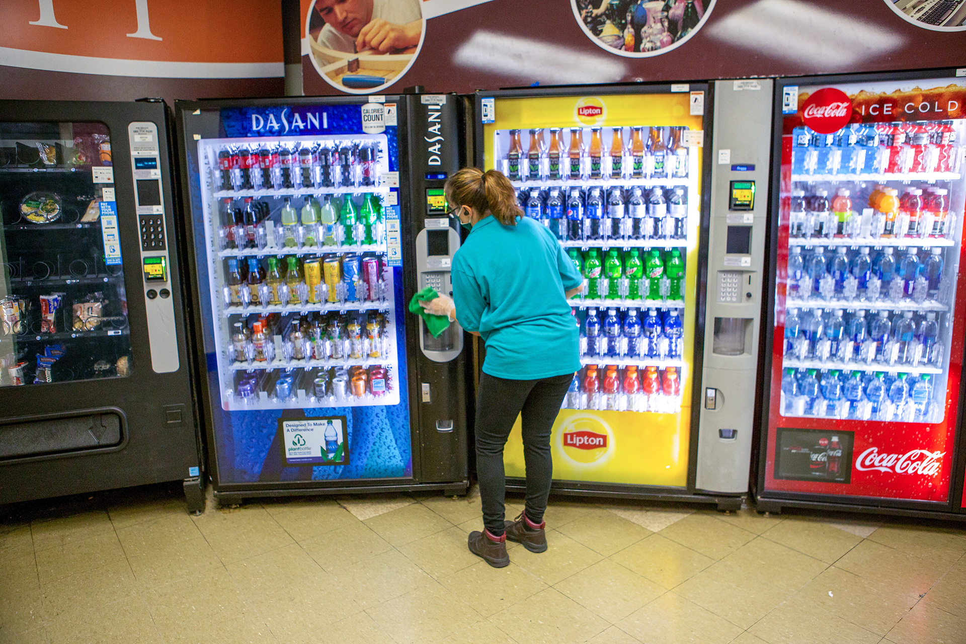 Conti wipes down what are considered a “high touch point” at R.I.T., vending machines, on October 19, 2020. She remarks, " I think we are all doing our parts and we are doing well." She then goes on to say, " R.I.T. has a good system. The green and blue towels are used for the high touch points only and nowhere else, so we don’t spread the germs."