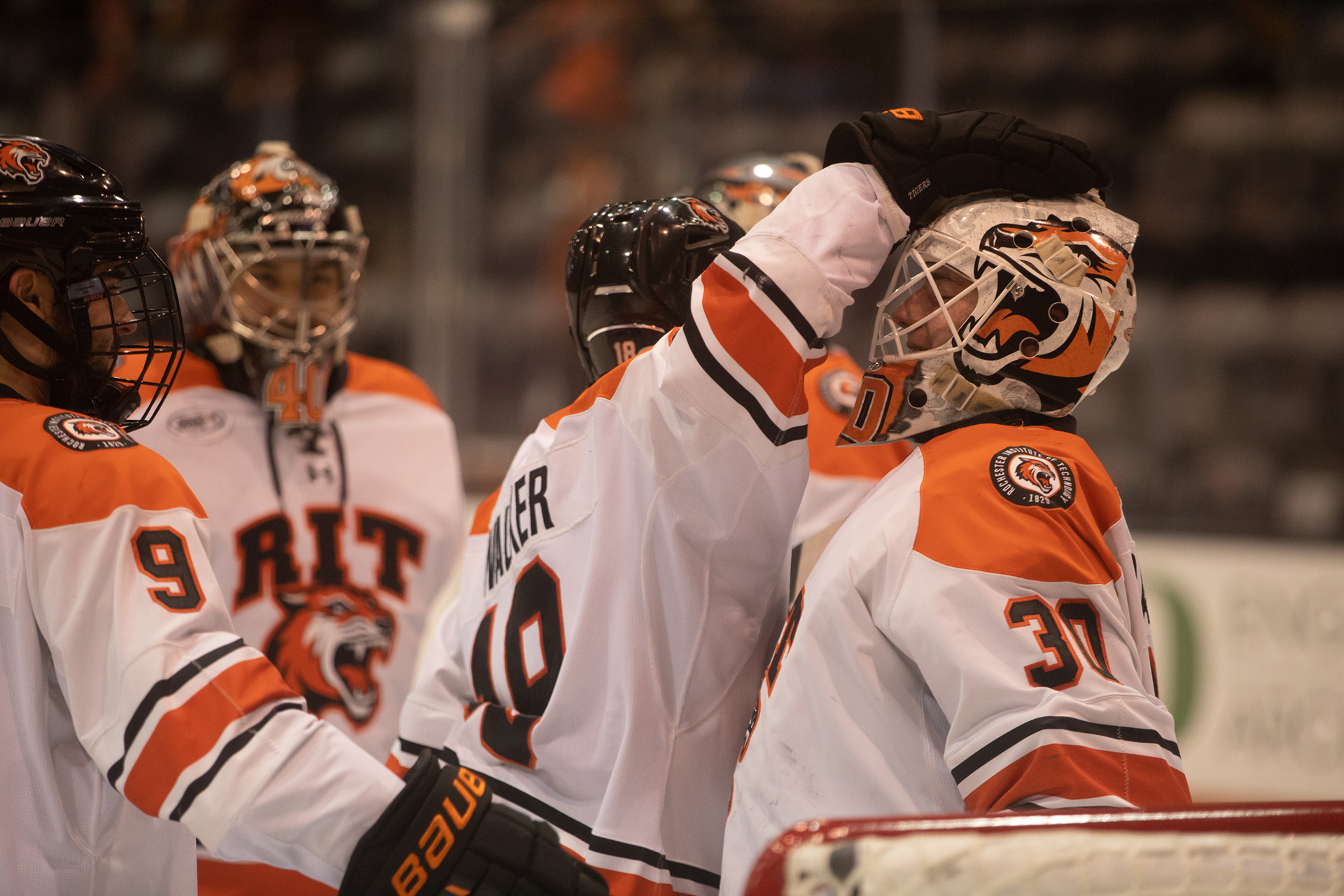 R.I.T. forward Kobe Walker (18) pats teammate and goaltender Tommy Scarfone (30) on the head after defeating Sacred Heart University in a 3-1 victory at the Gene Polisseni Center in Rochester, N.Y. on March 13, 2022. The victory moved R.I.T. from quarterfinals to the semifinals.