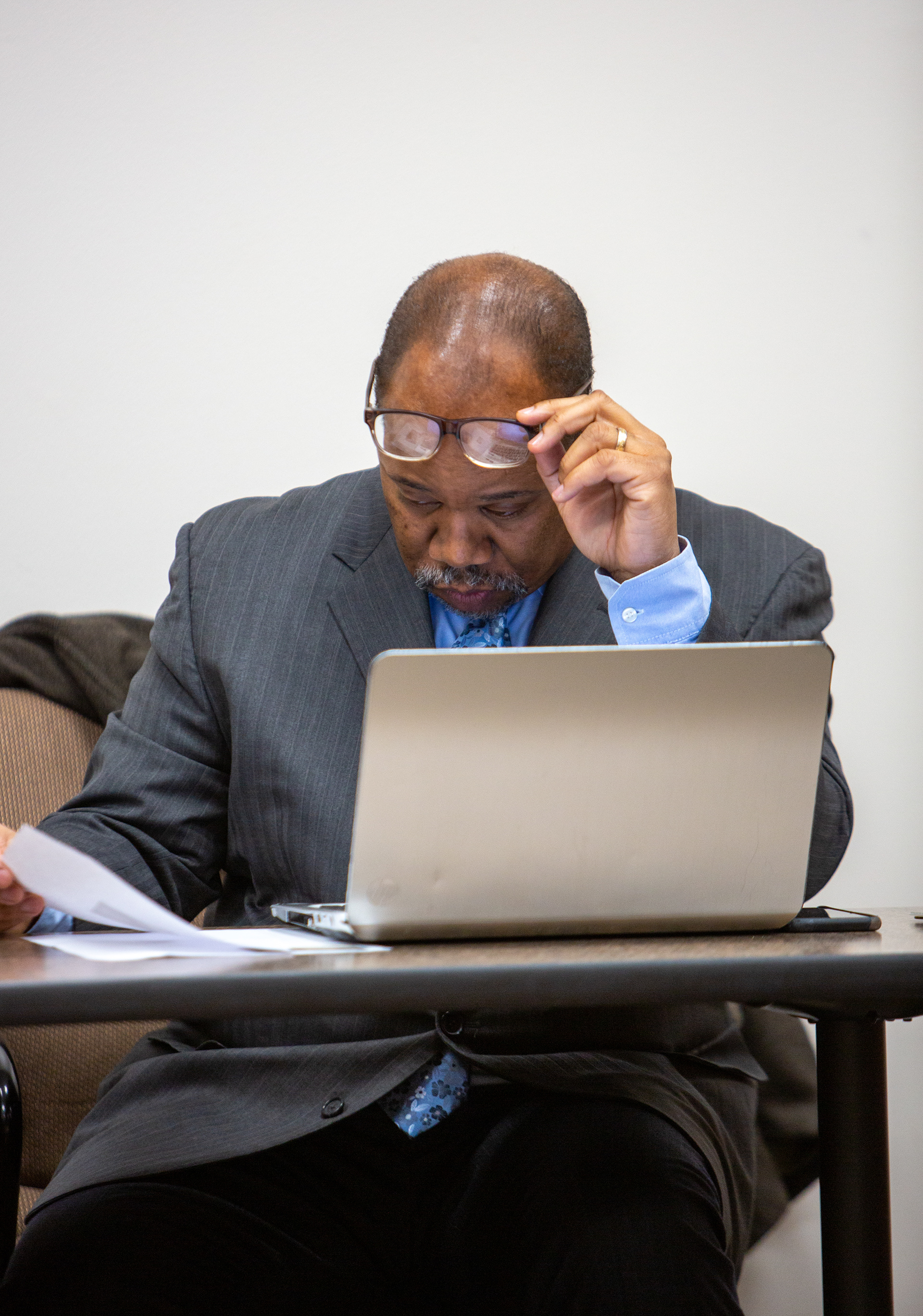 White, while sitting with his client, examines the paperwork for his client’s deal. December 12, 2019 in Greece, N.Y.