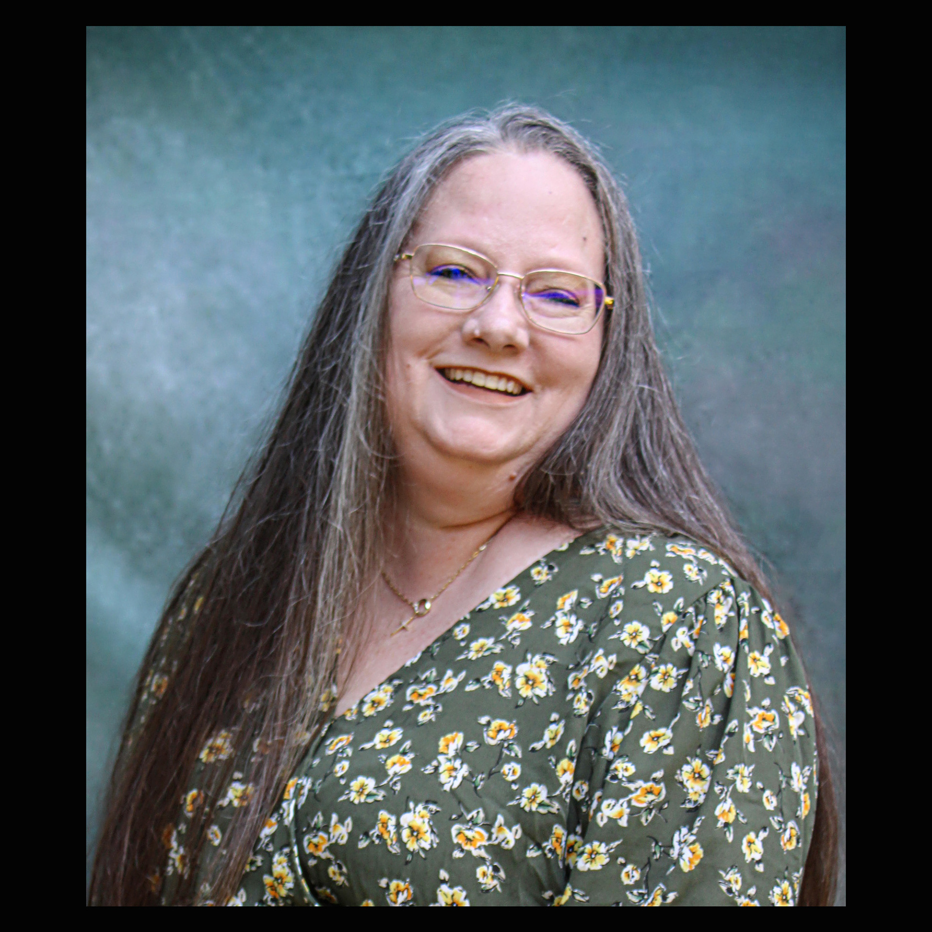 Studio portrait session, teal backdrop.
