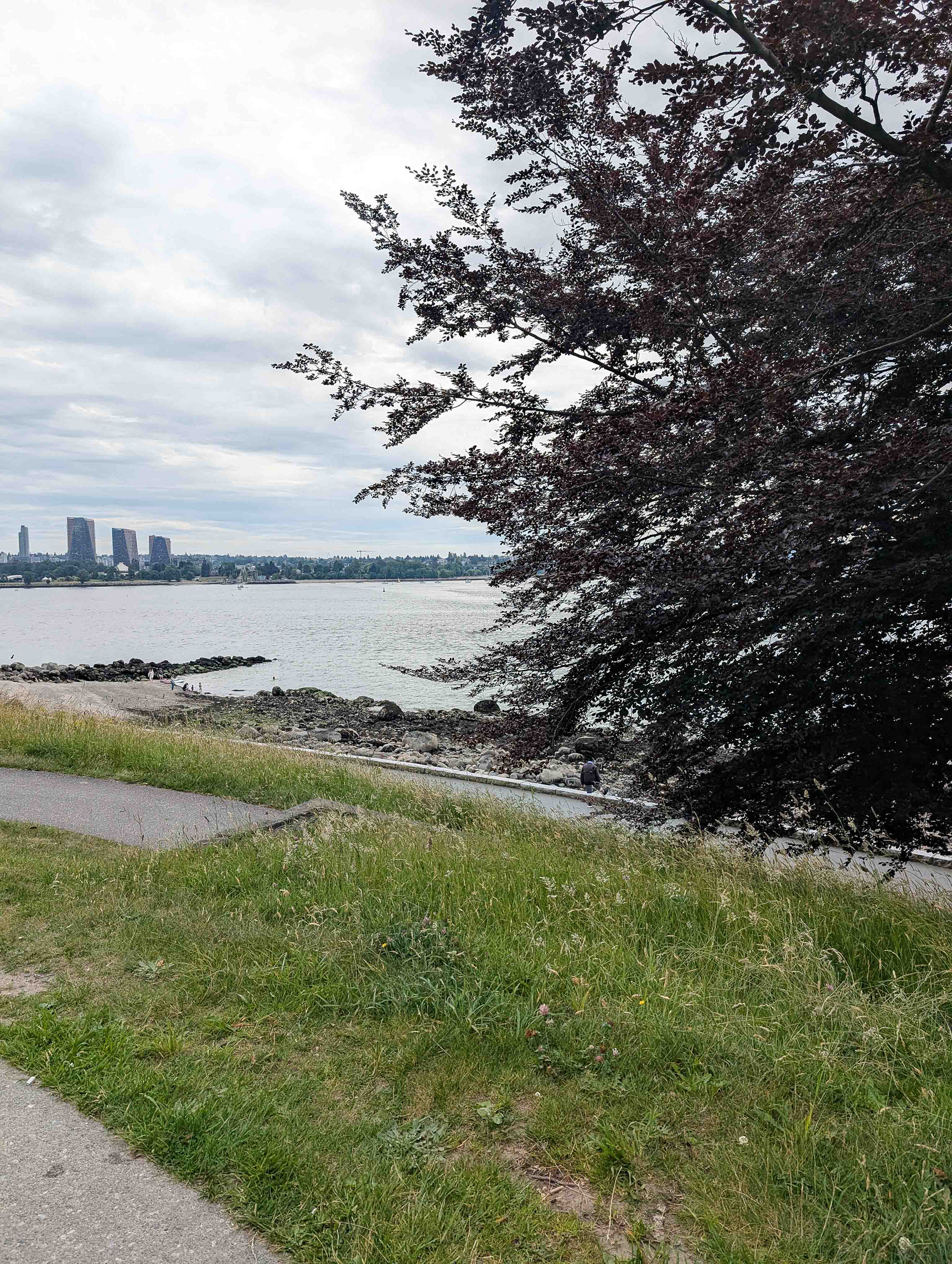 a photo of the left view, towards English Bay and across the water, featuring an outcropping of rocks in the distance.