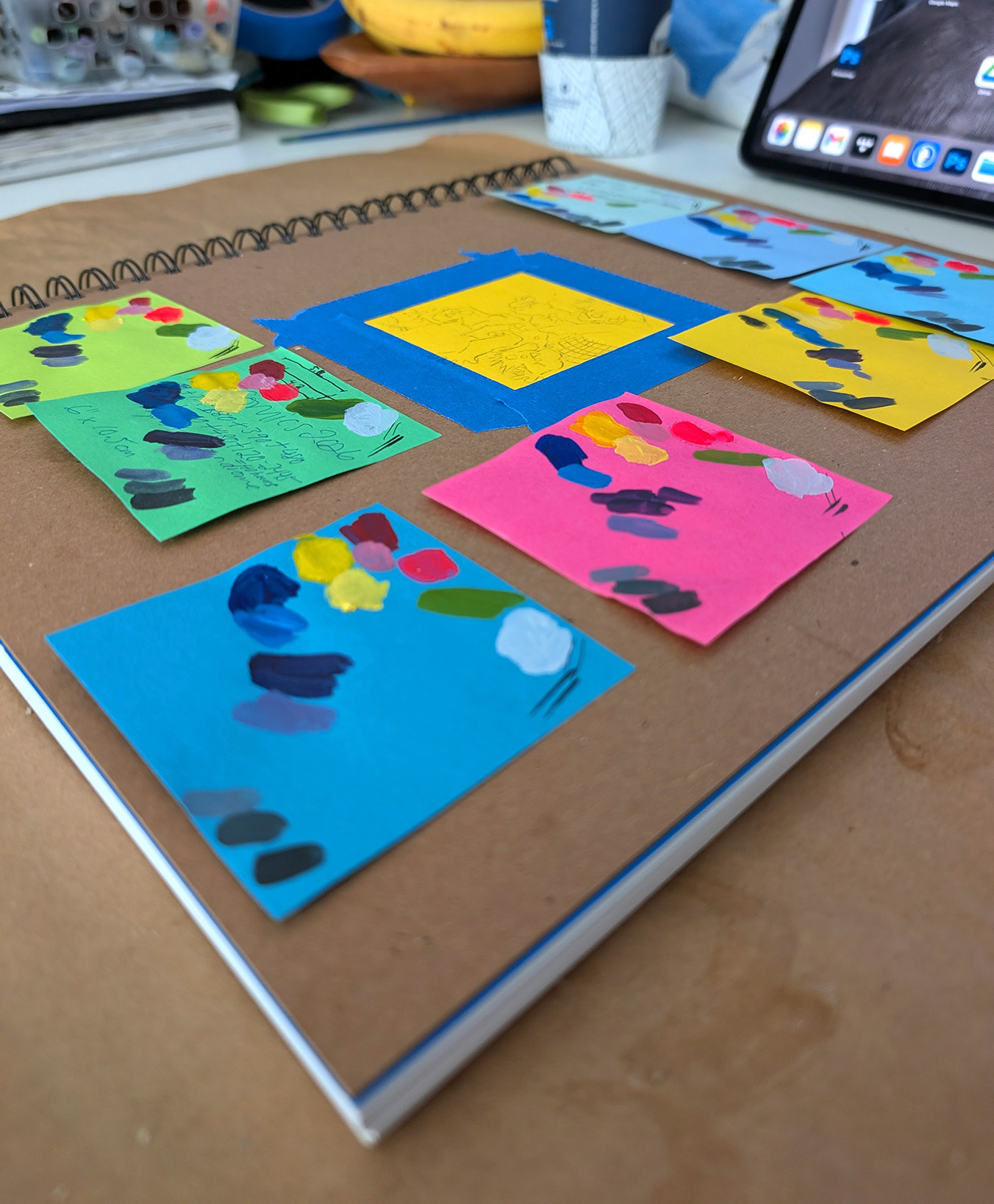 Swatches of acrylic paint on each colour of post-it note I was planning to use, stuck on my sketchbook.