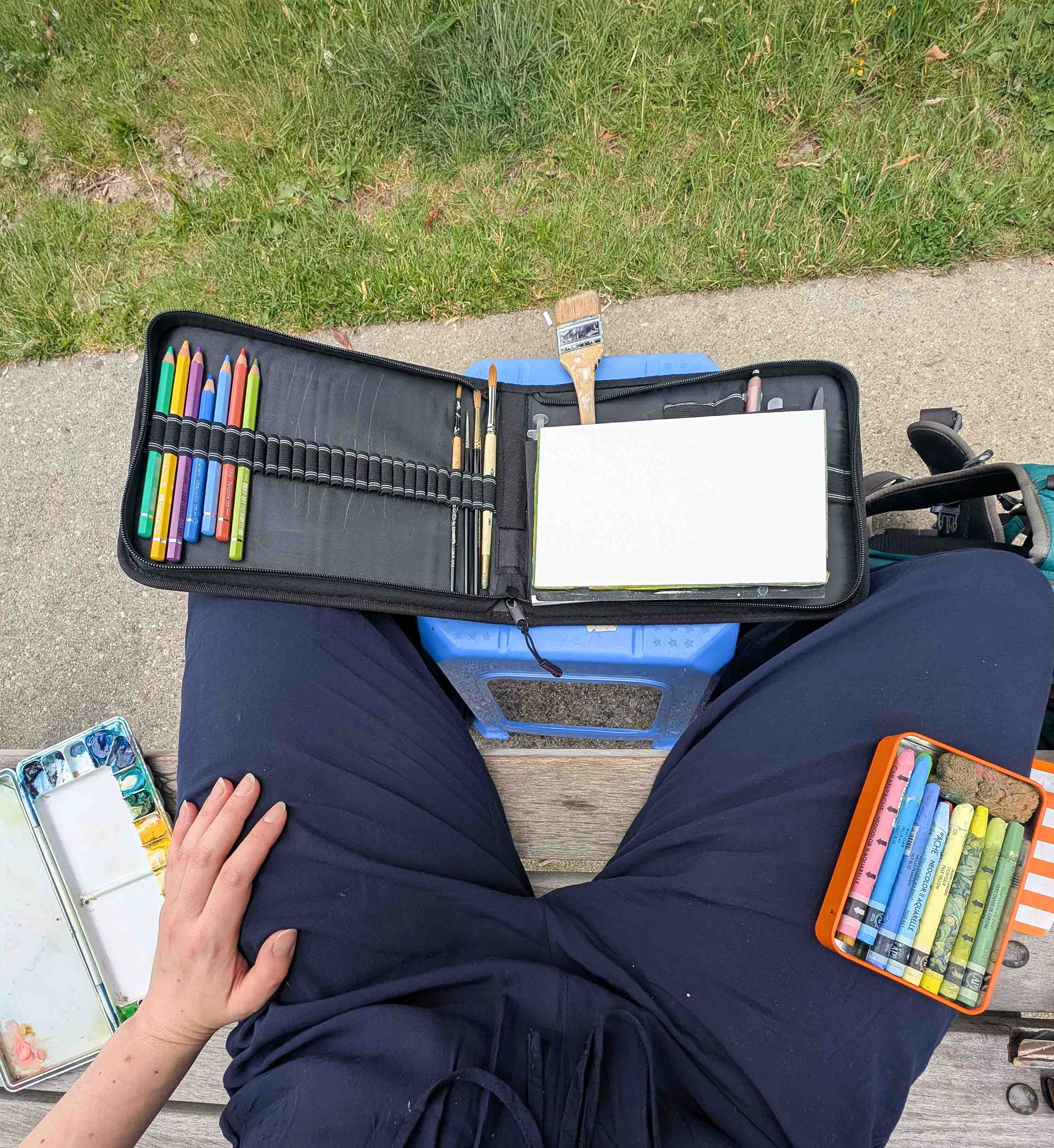 an overview of my setup, including my stool (table), paints, watercolour pencils and neocolour II pastels