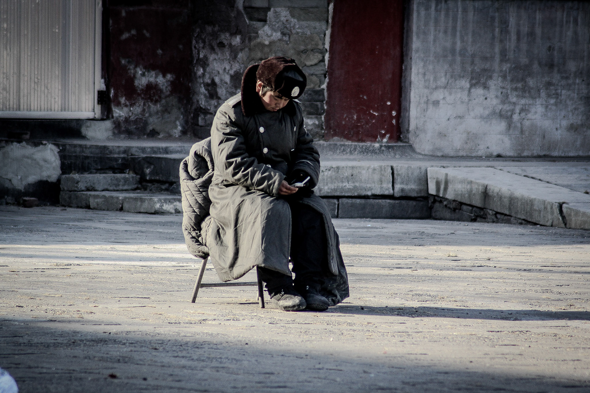 Rocken sparad från kulturrevolutionens dagar? Mobilen i handen från senare datum.