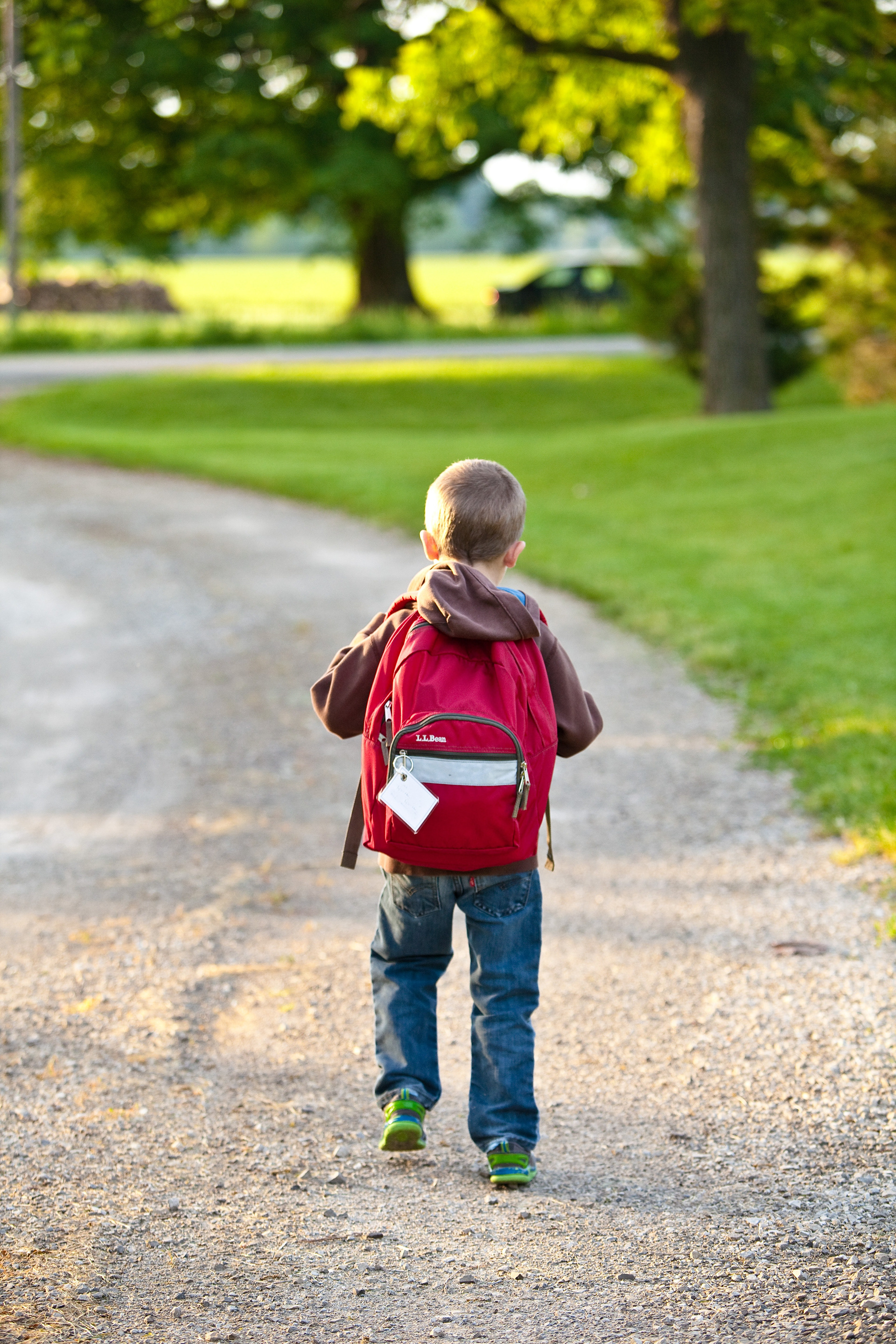 Boy walking from school on sunny day