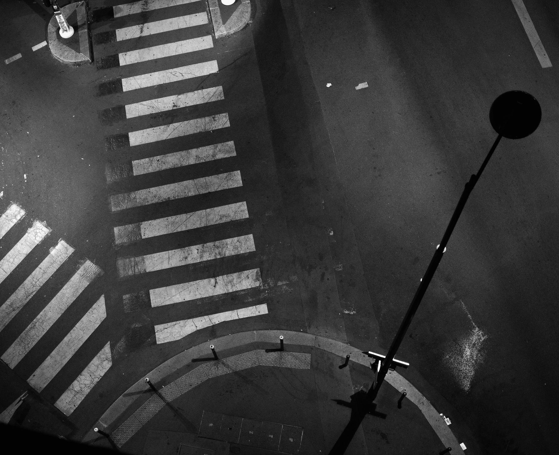 With the graphical geometry in the photo I like also a funny effect: the lantern turn away form crossroads and its light falls on other direction, but crosswalks are still in light.