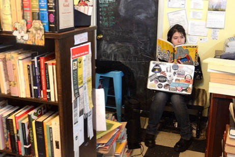 Dani Perez sits in Yellow Dog Bookshop in downton Columbia, Mo on Tuesday, April 3, 2018 and reads a book entitled Outlaw Animation to pass the time. After moving to Columbia, Perez applied for the job on a whim because she realized she could see herself “really getting into a bookshop.”