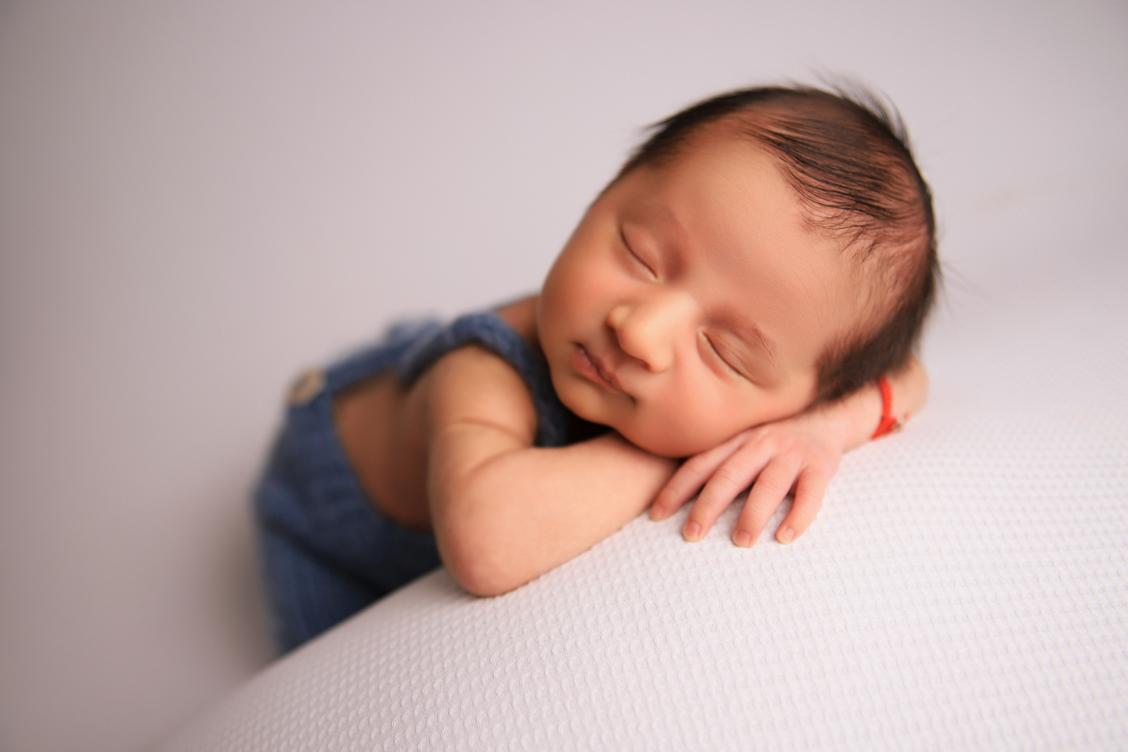 Schlafendes Neugeborenes in einer Chinnypose - Babyhooting in Pforzheim