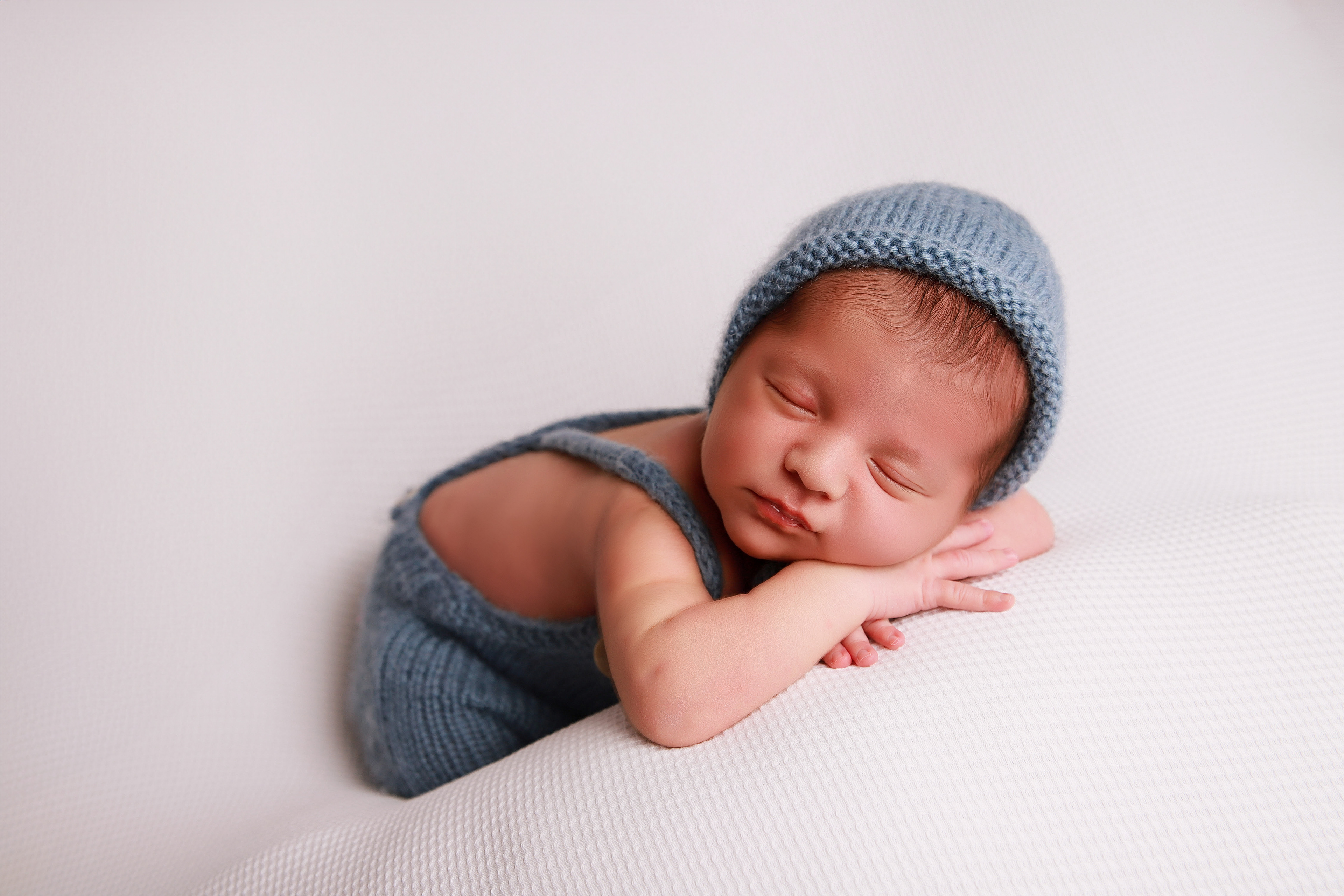 Schlafendes Neugeborenes in einer Chinnypose - Babyhooting in Pforzheim